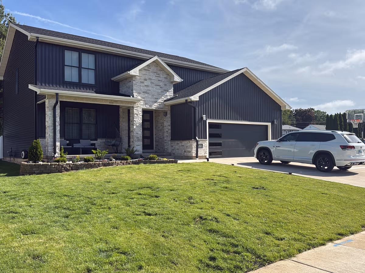 Front exterior of a modern retirement home with a lawn, driveway, and parked SUV.