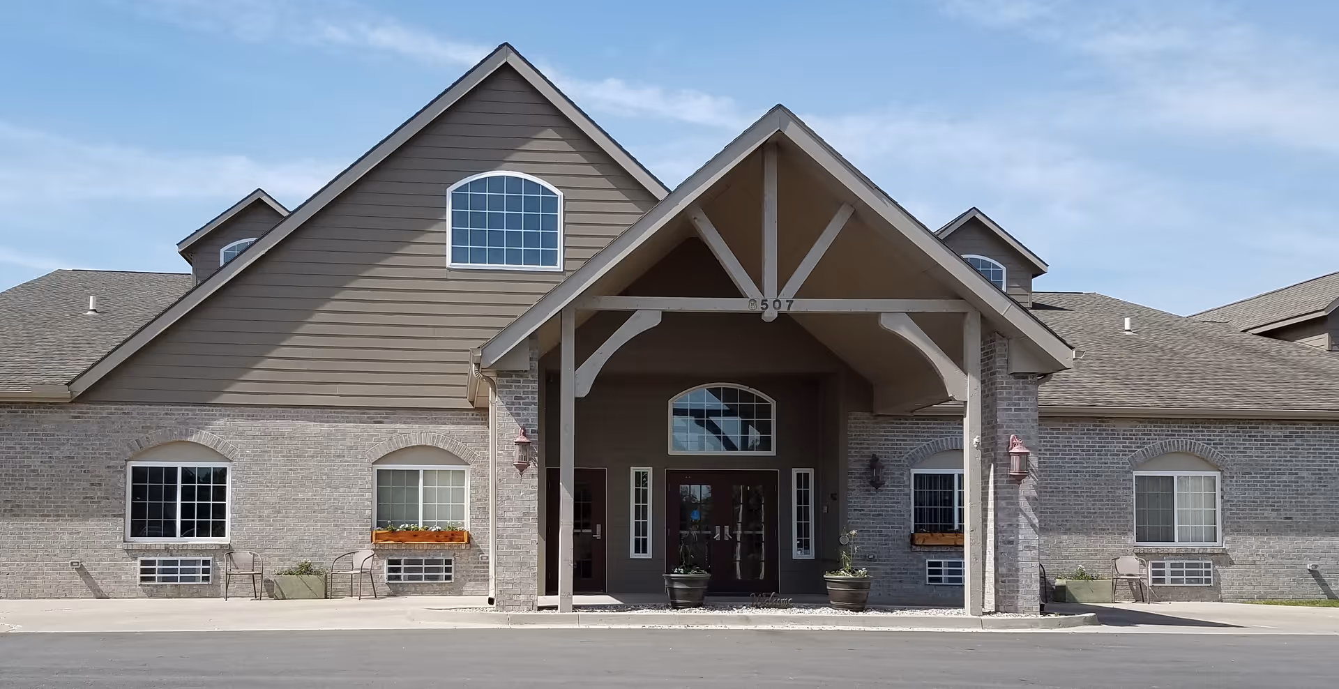 Front view of Homestead Assisted Living of La Vista with brick exterior and entrance canopy