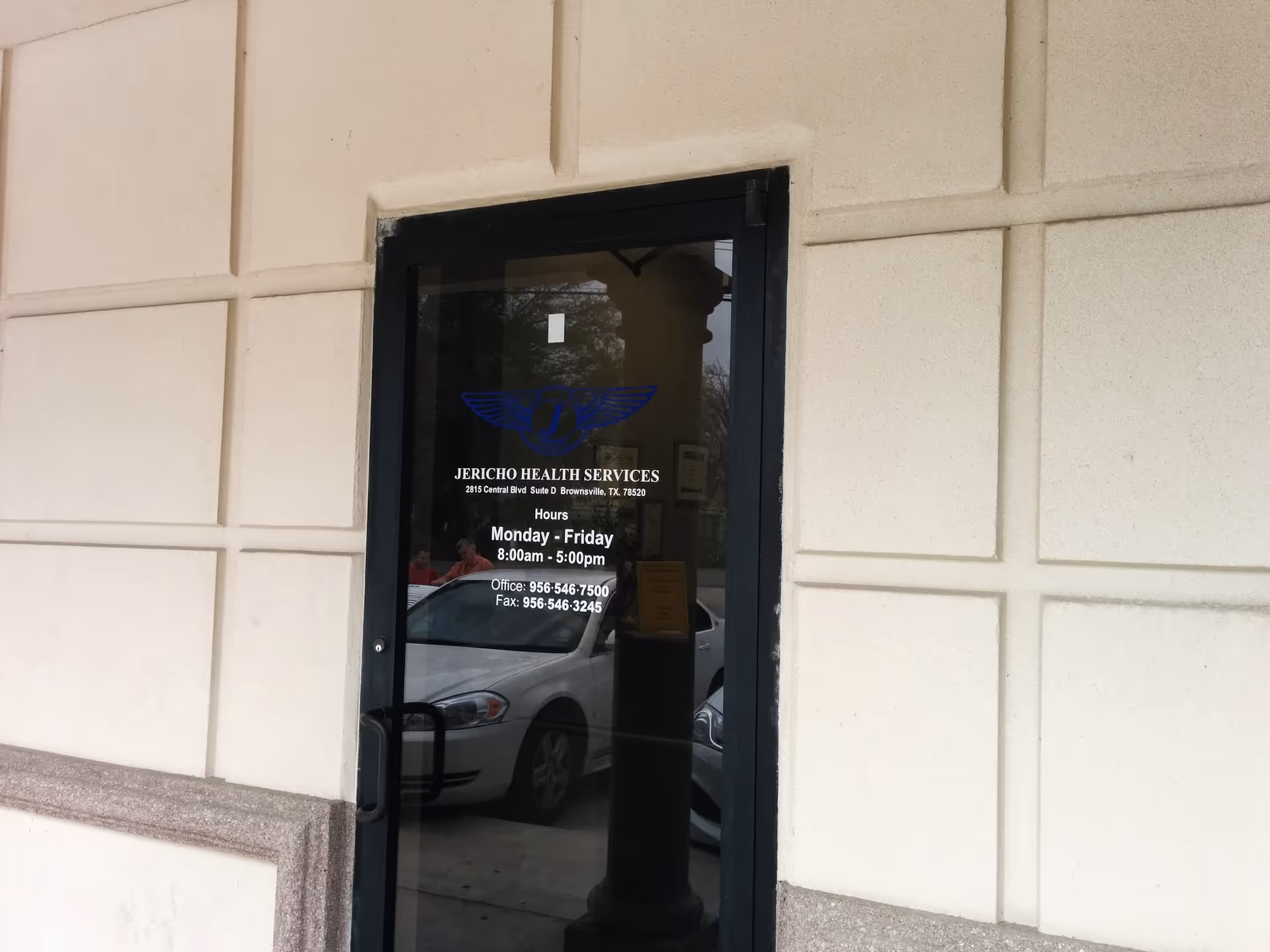 Jericho Health Services entrance door on beige wall with posted hours.