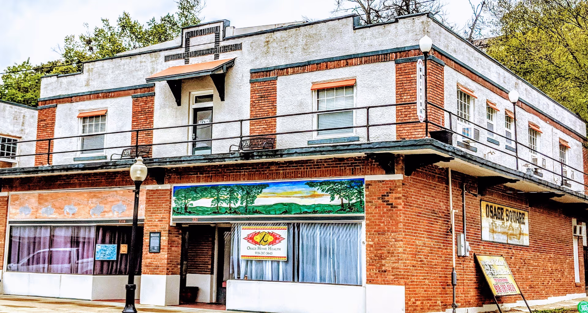 Brick, two-story building with Osage Nation Home Health signage on storefronts.