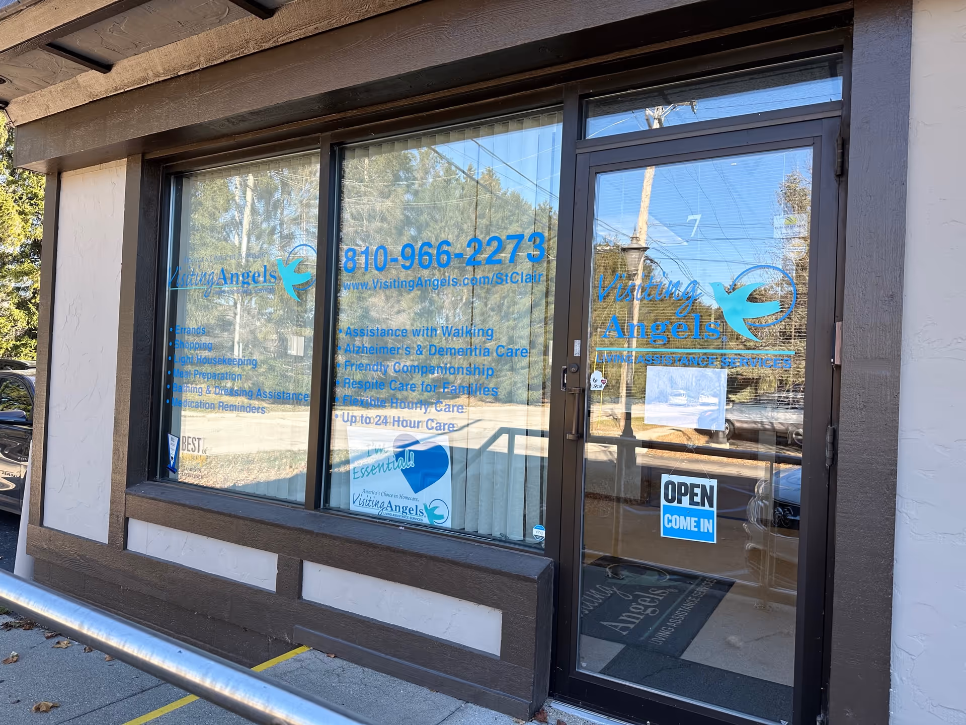 Exterior of Visiting Angels storefront with glass windows and an open door.