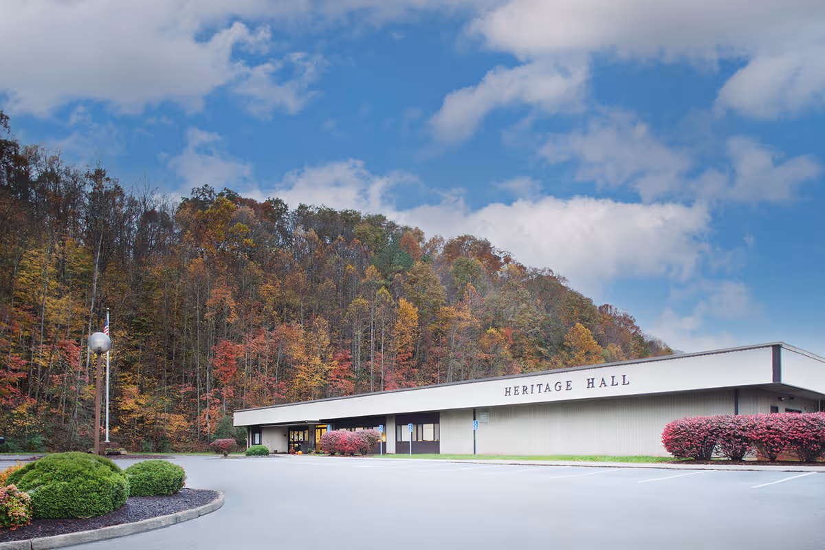 Exterior view of Heritage Hall Clintwood with fall foliage and a parking lot.
