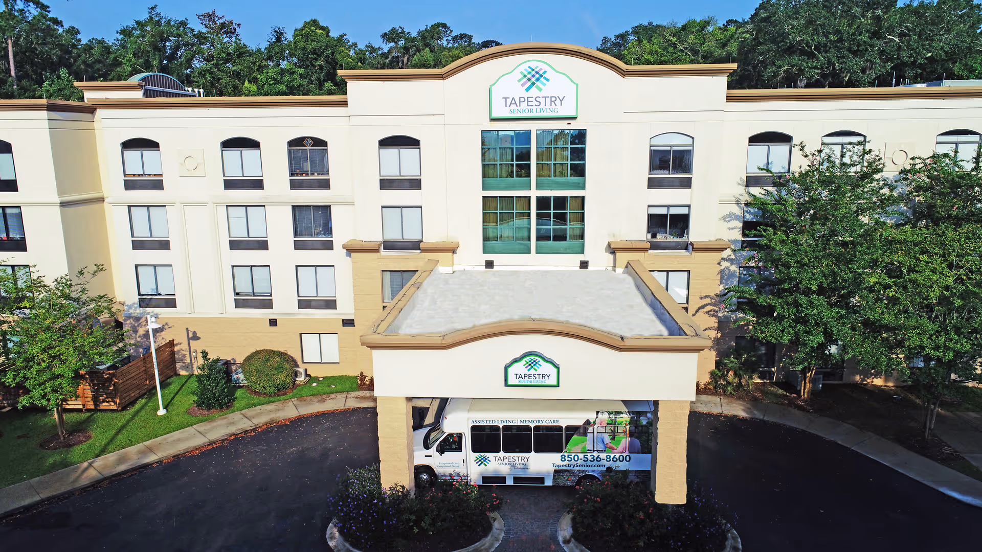 Front exterior of the Tapestry Senior Living Lakeshore building with an entrance canopy and shuttle van parked underneath.