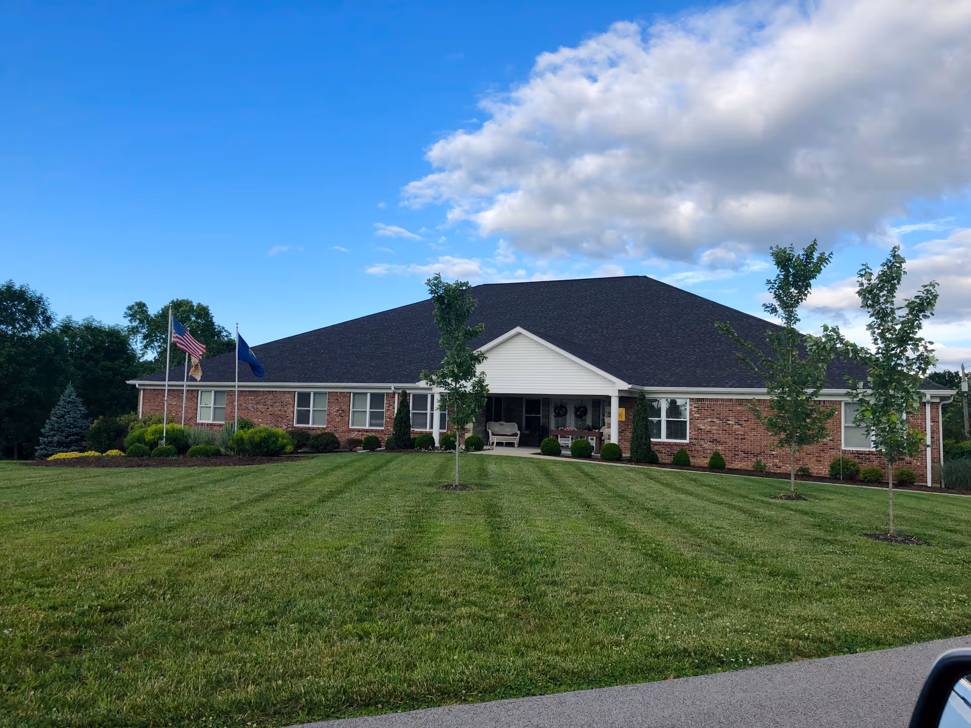 BeeHive Homes of Leitchfield exterior: brick, single-story building with a manicured lawn and entrance.
