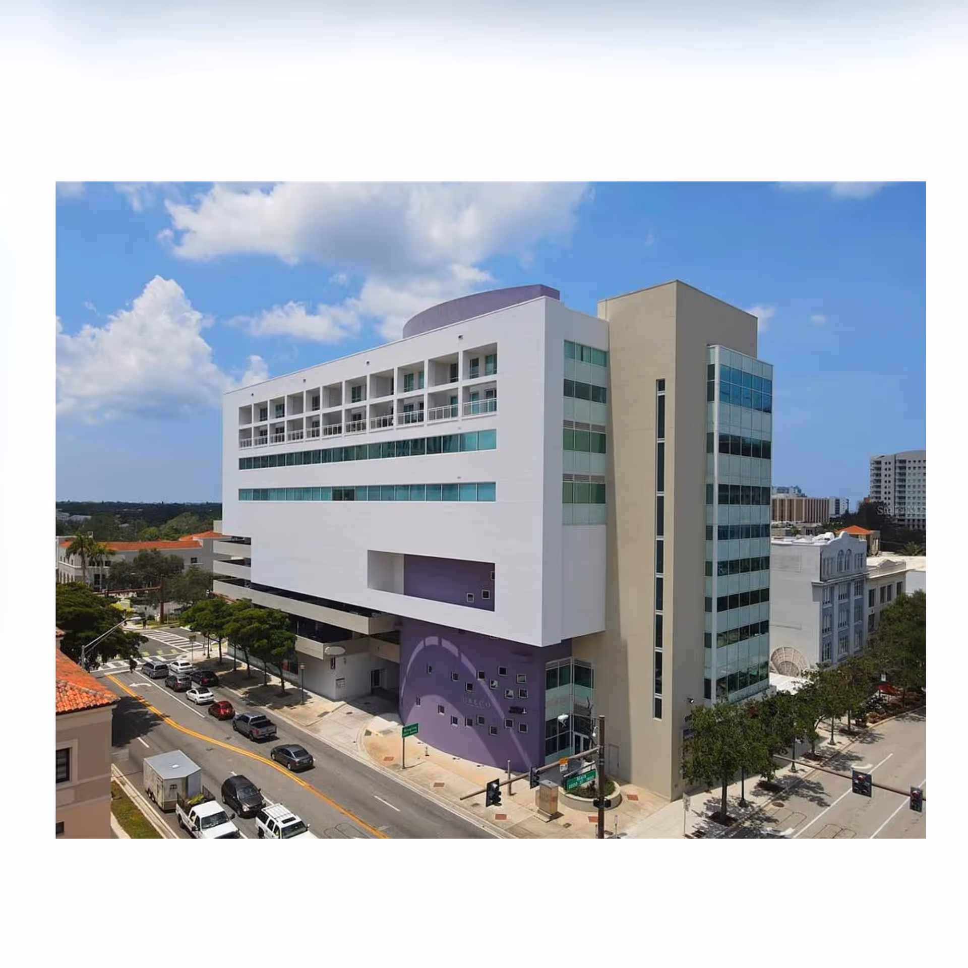 A modern multi-story senior living facility with purple accents along a city street