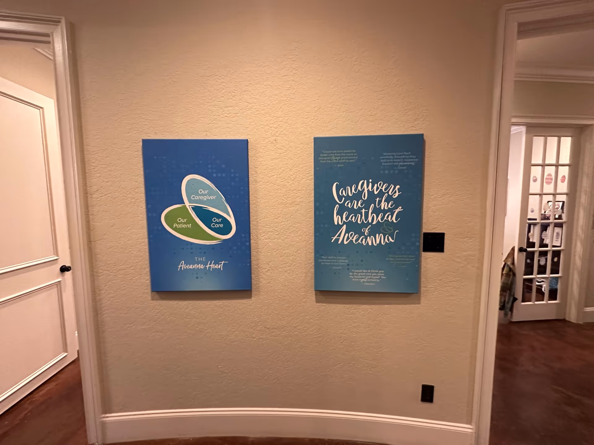 Two blue posters hang on a beige hallway wall inside Aveanna Home Health.