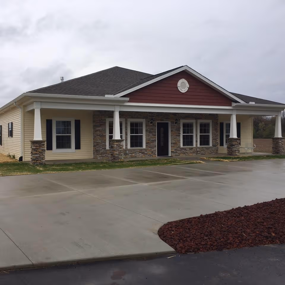 Single-story senior living facility with stone accents and a covered front entrance.