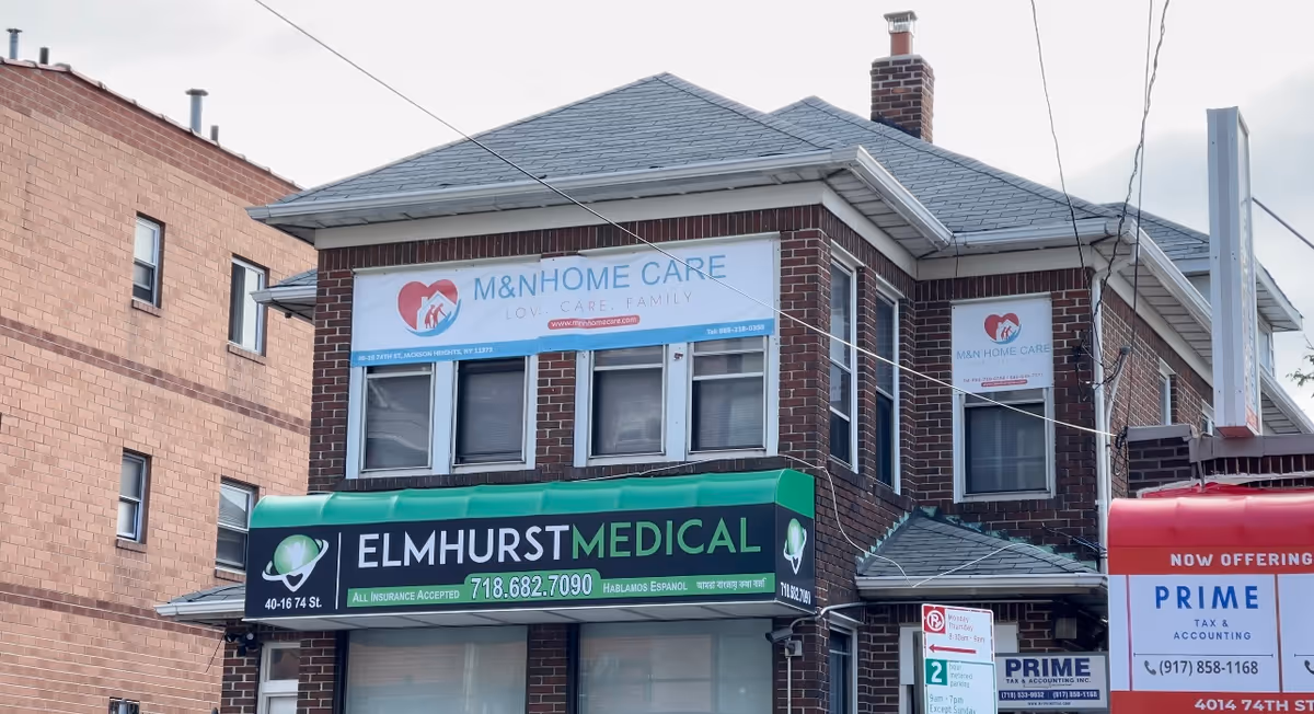 Two-story brick building with medical and home care signs along a busy street.