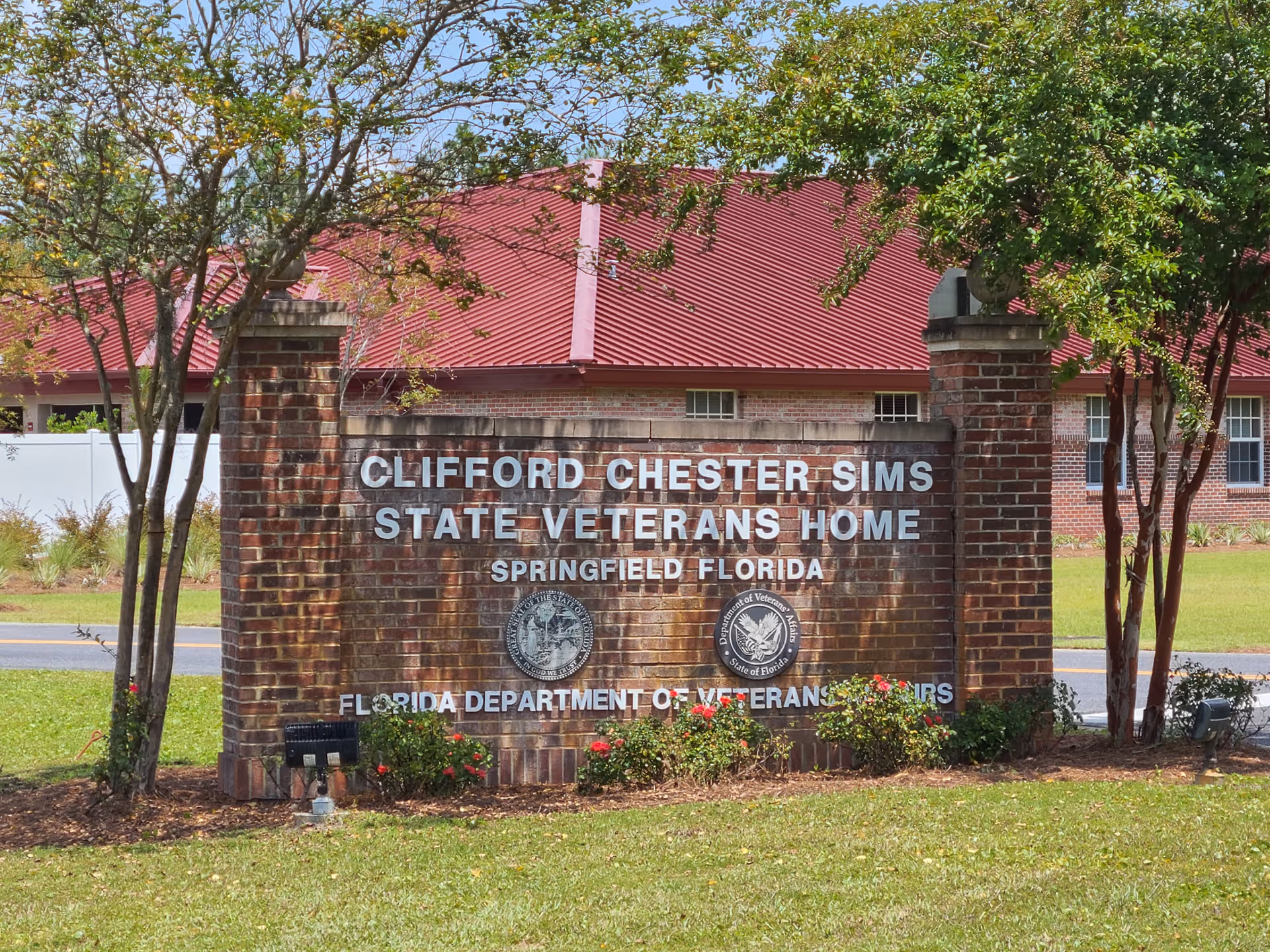 Brick sign for Clifford Chester Sims State Veterans Home in front of building.