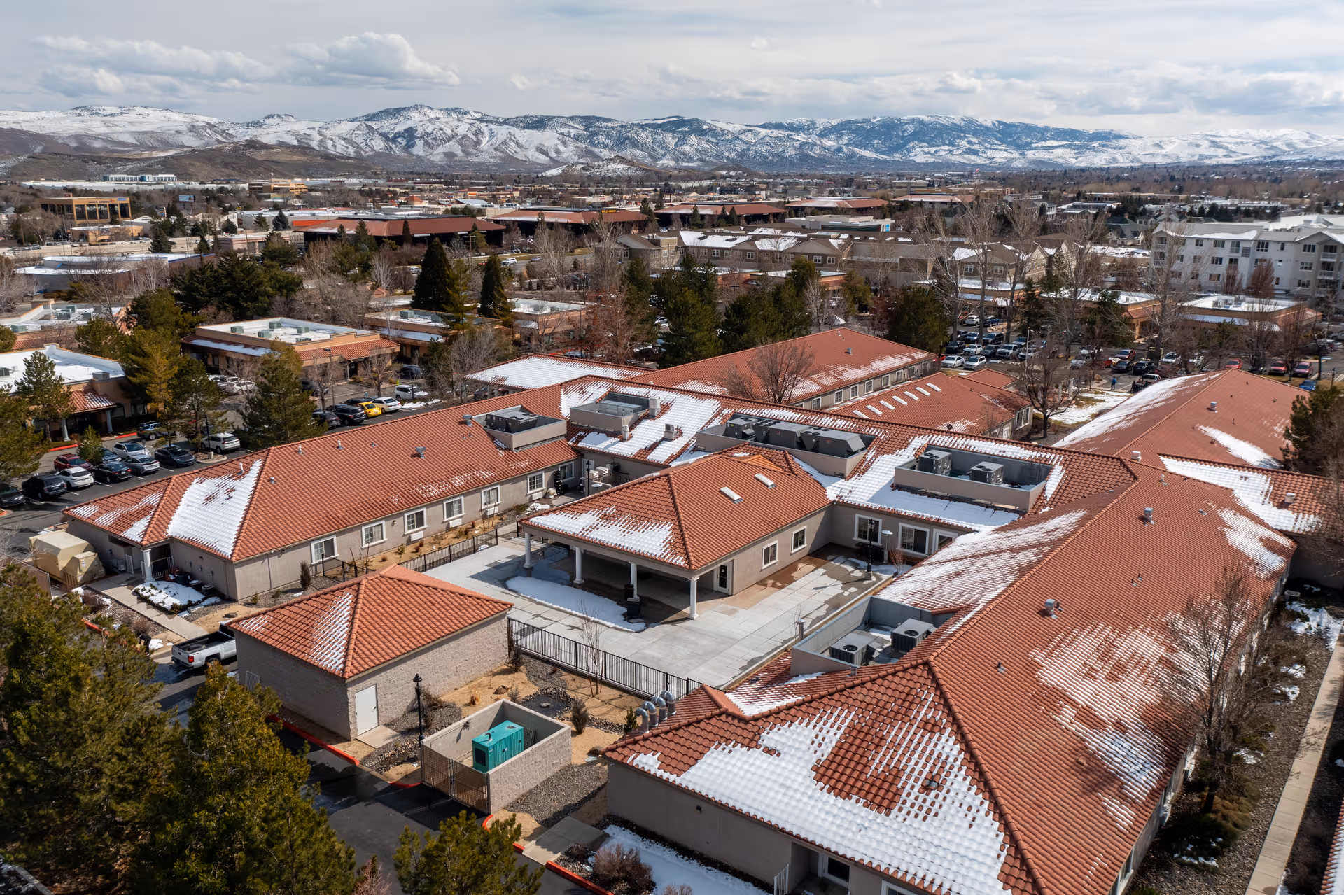 Aerial view of Alta Skilled Nursing and Rehabilitation Center campus with snow-dusted red-tiled roofs.