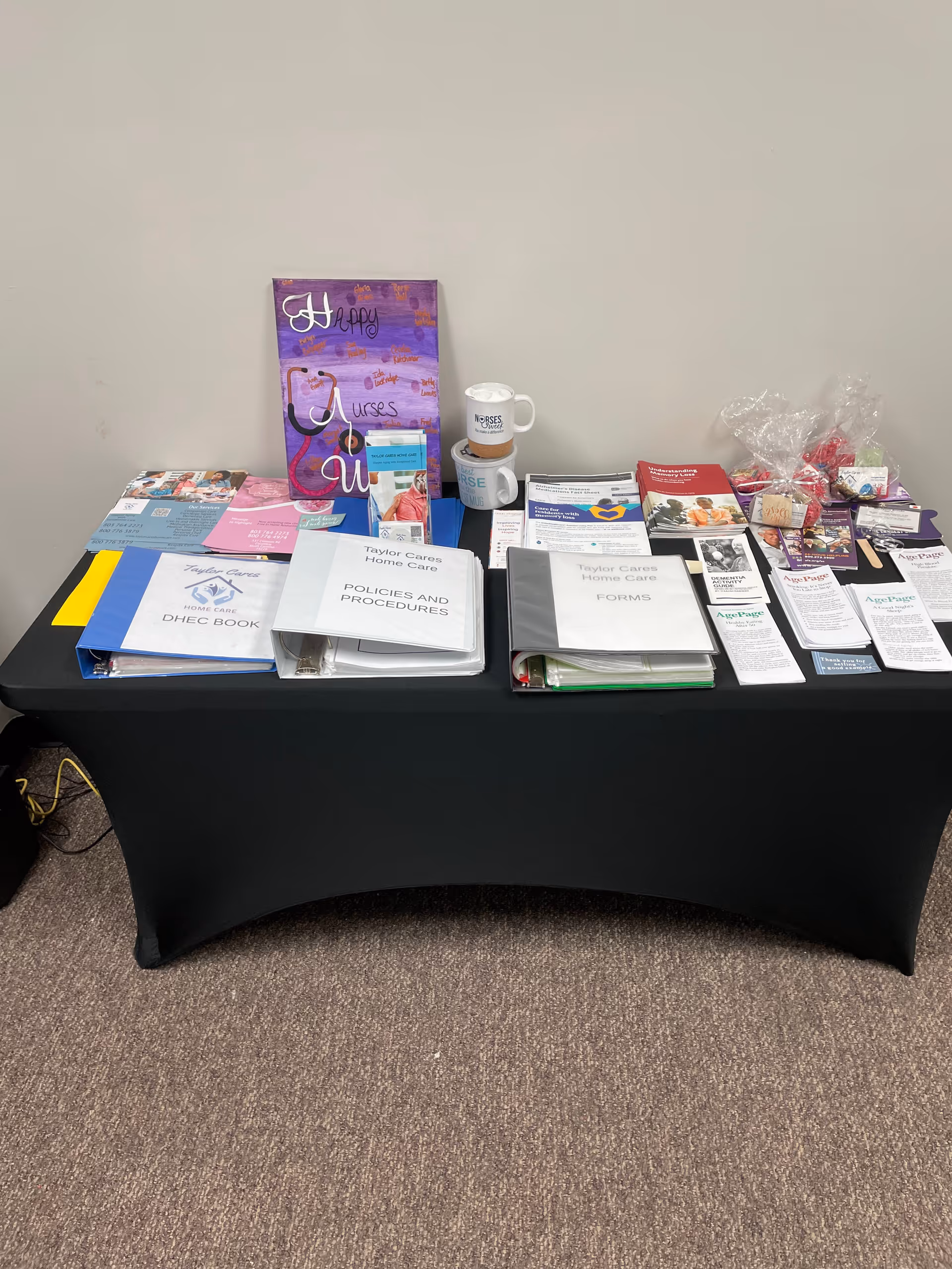 Table with brochures, forms, and promotional materials for Taylor Cares Home Care.