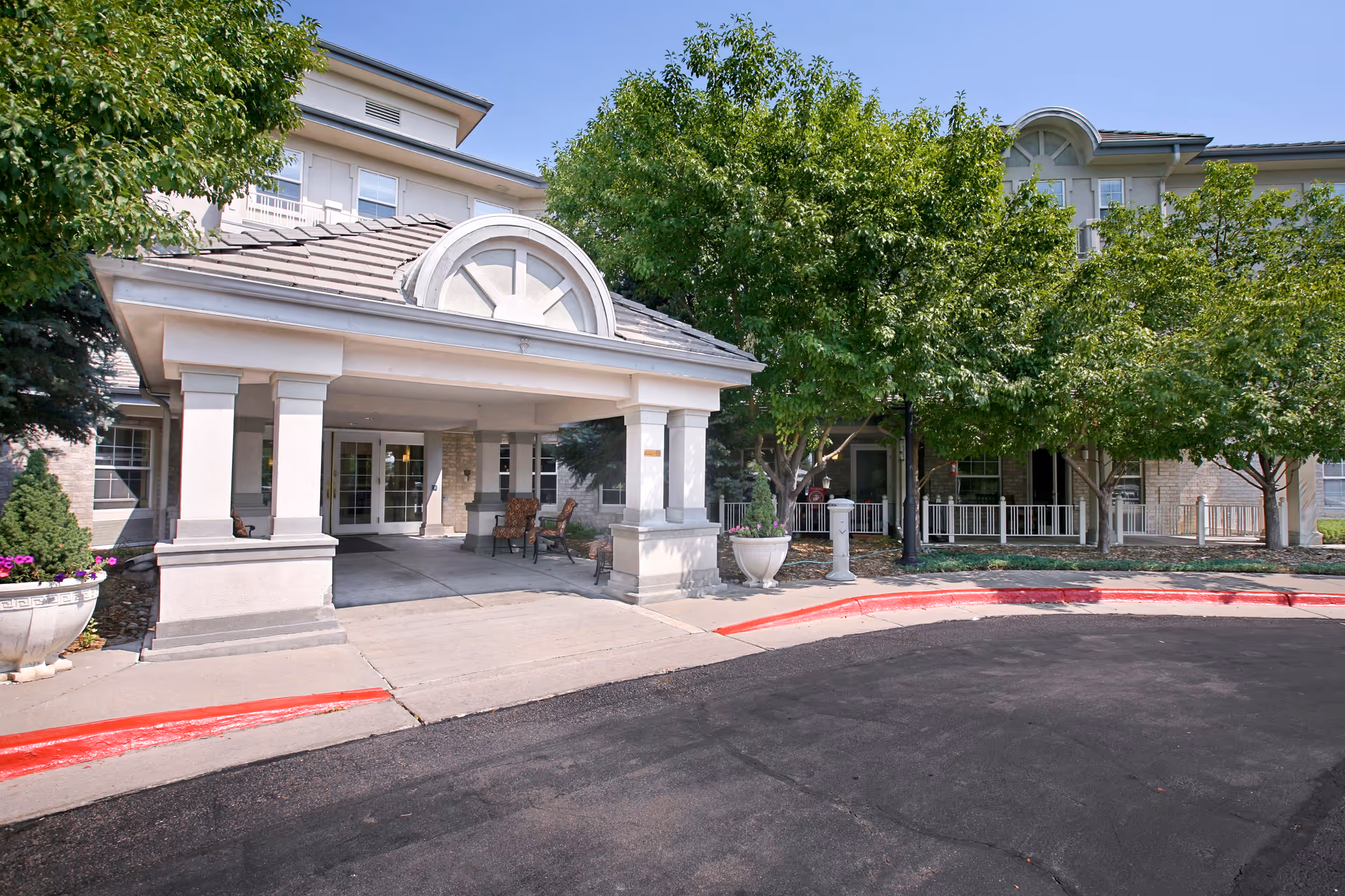 Front entrance of Belleview Suites at DTC with a covered porte-cochere and trees.
