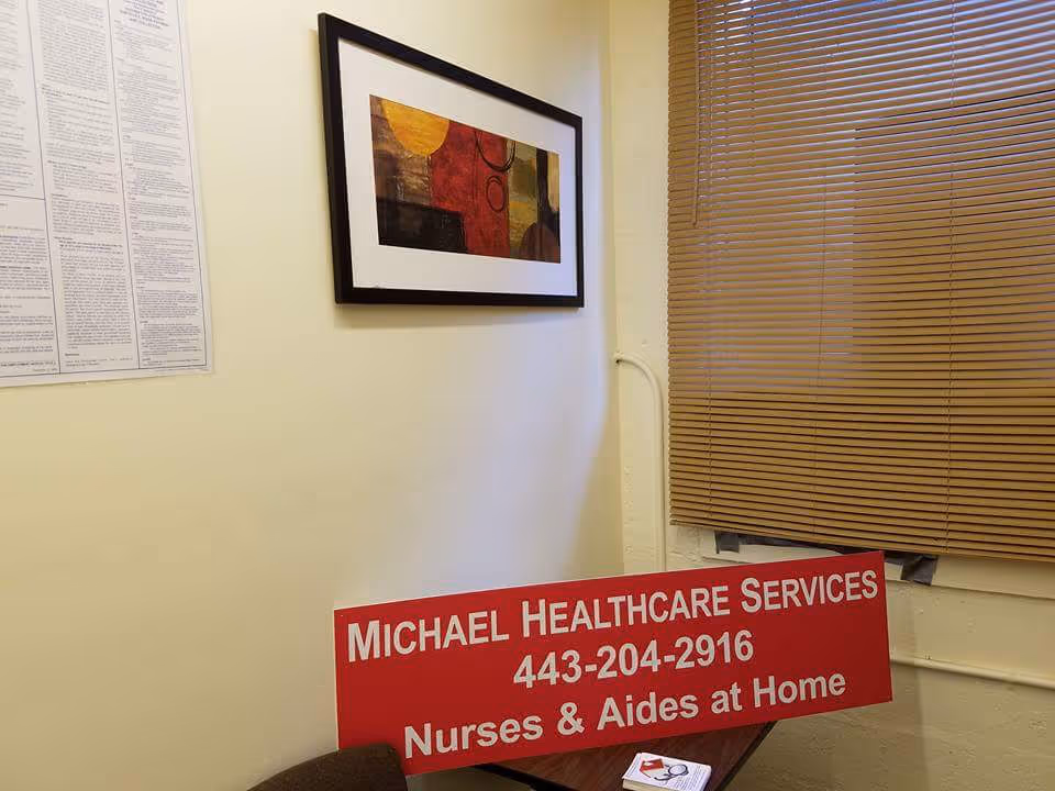 Red Michael Healthcare Services sign on a table inside a small windowed interior corner