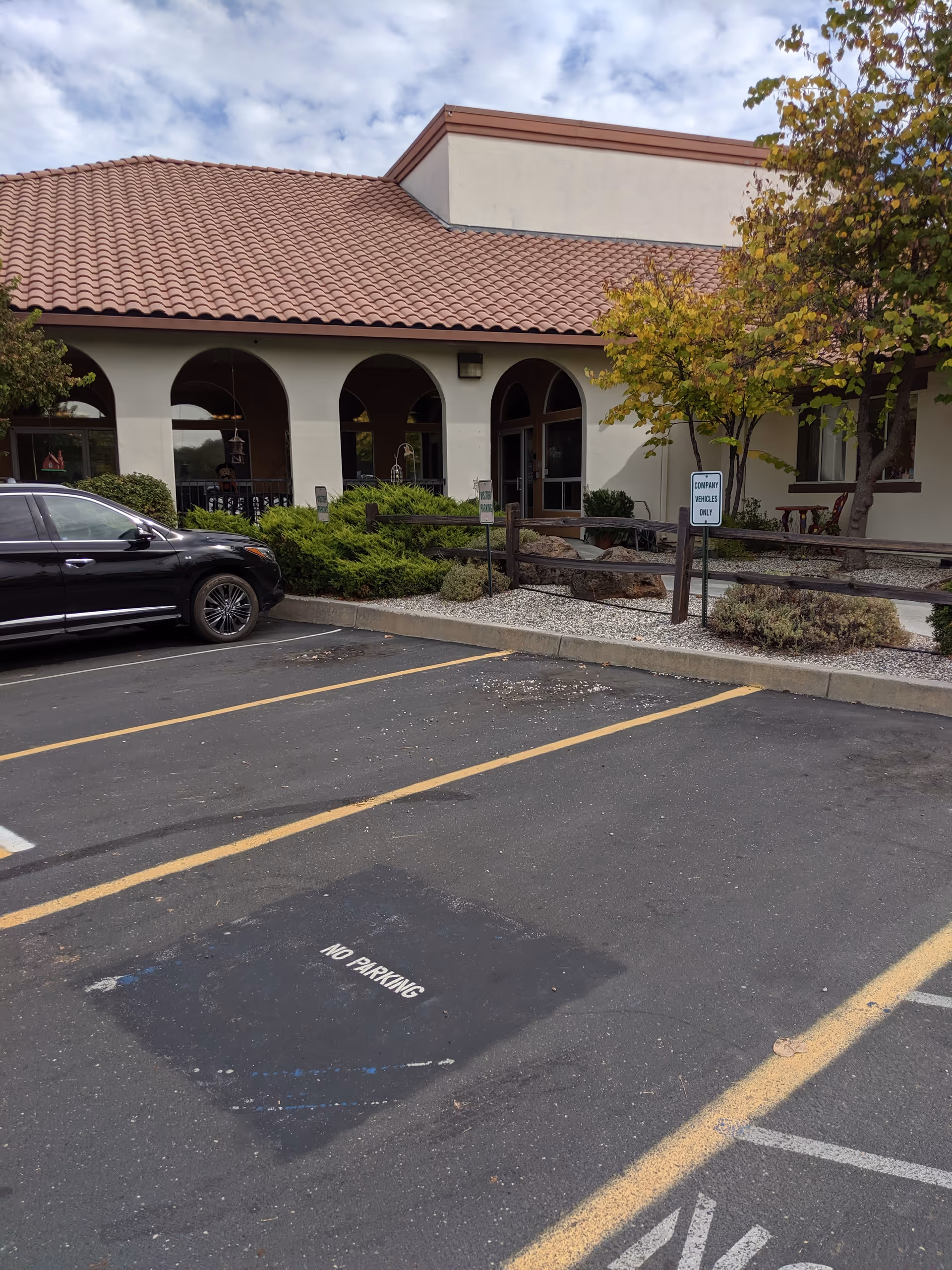 Exterior view of a senior care center with a tiled red roof and arched entryway.