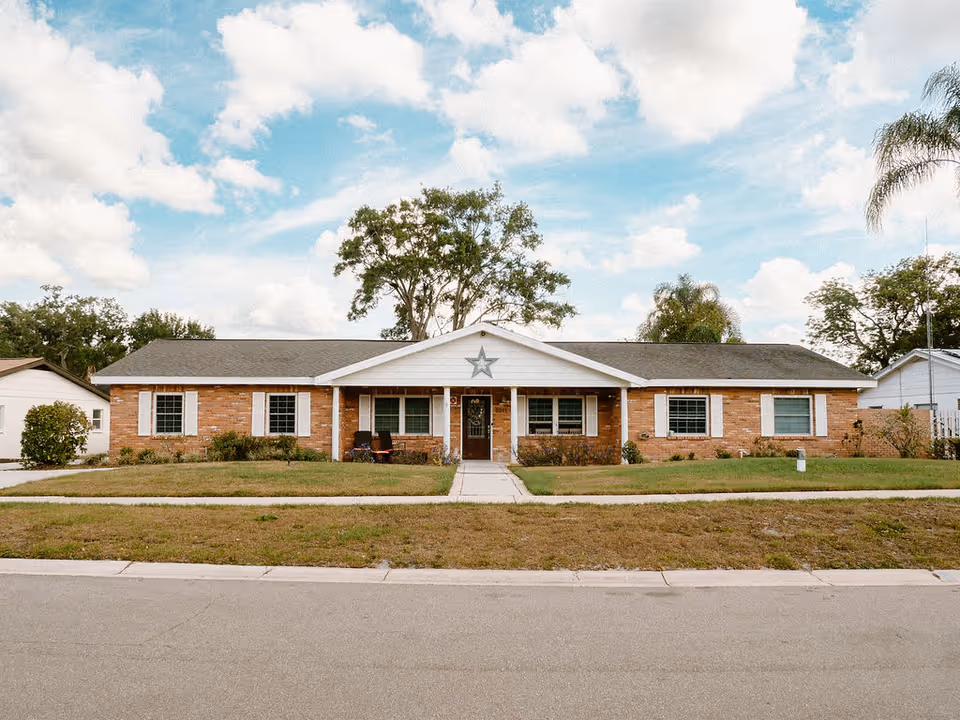 Single-story brick facility with a star on the gable, front entrance, and manicured lawn.