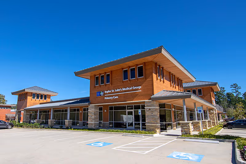 Exterior view of a wood-clad medical facility with front parking.