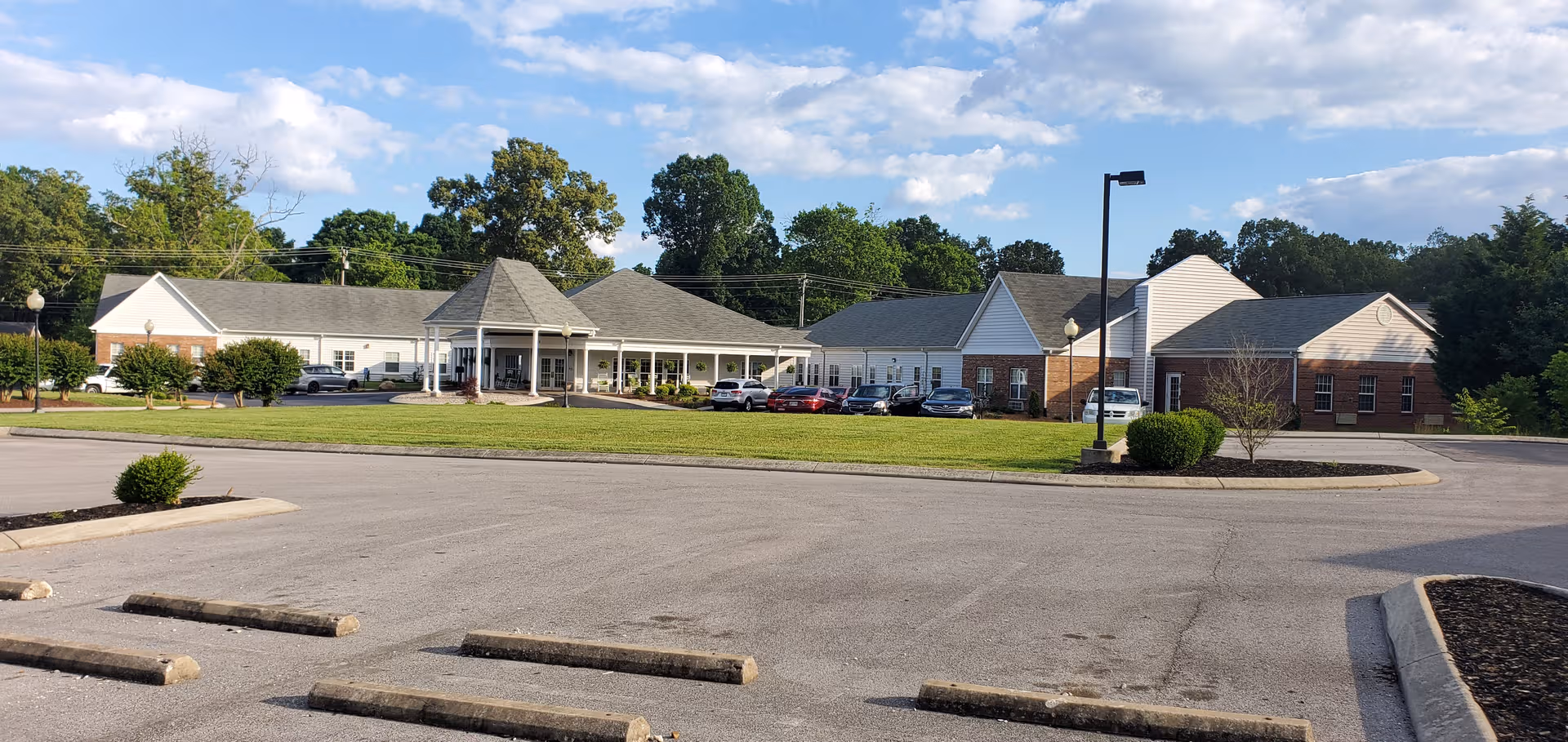 Exterior view of Morning Pointe of Tullahoma with building, parking, and greenery.