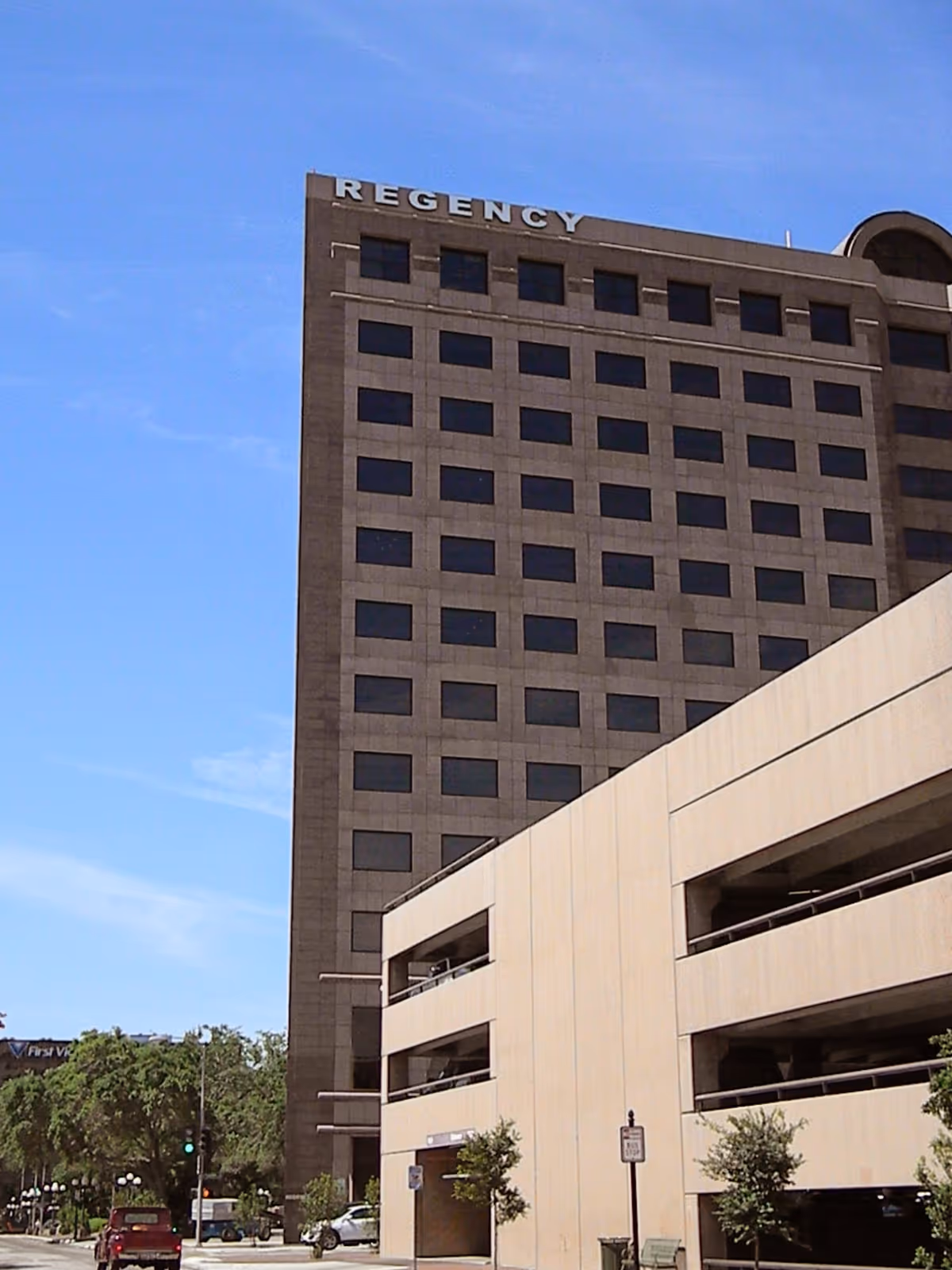 Exterior view of a tall Regency facility building with many windows and street access.