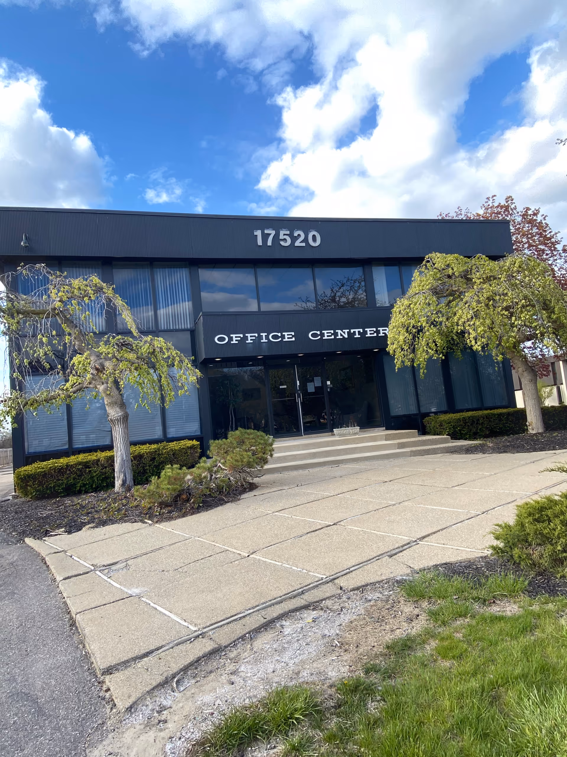 Front facade of a two-story office building with large glass windows and the 17520 address.