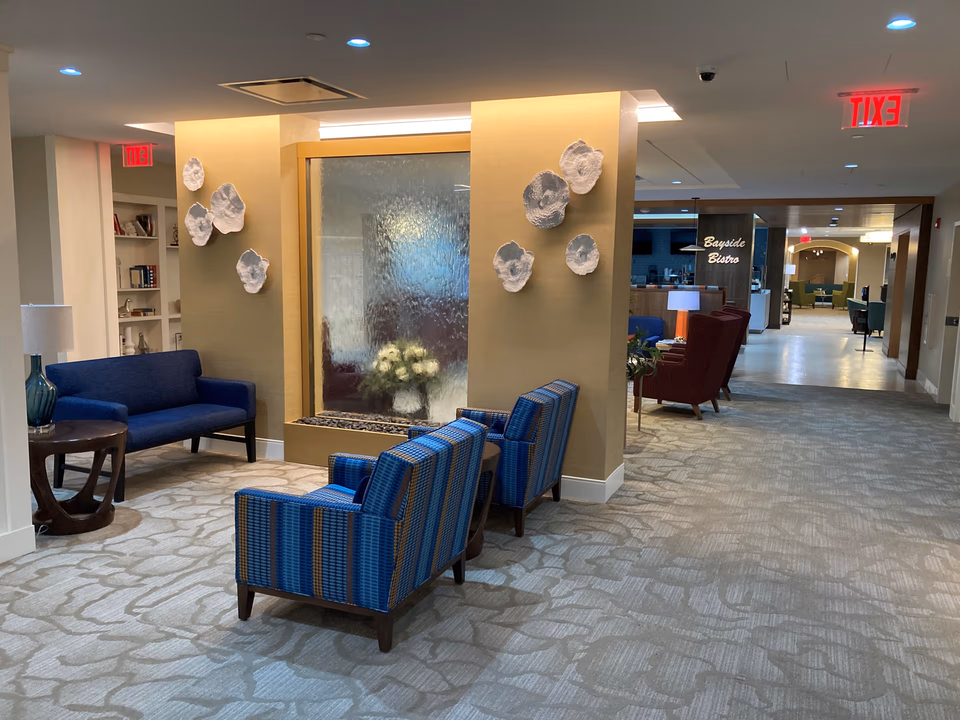 Interior lobby of United Methodist Communities at The Shores with blue seating and fountain.