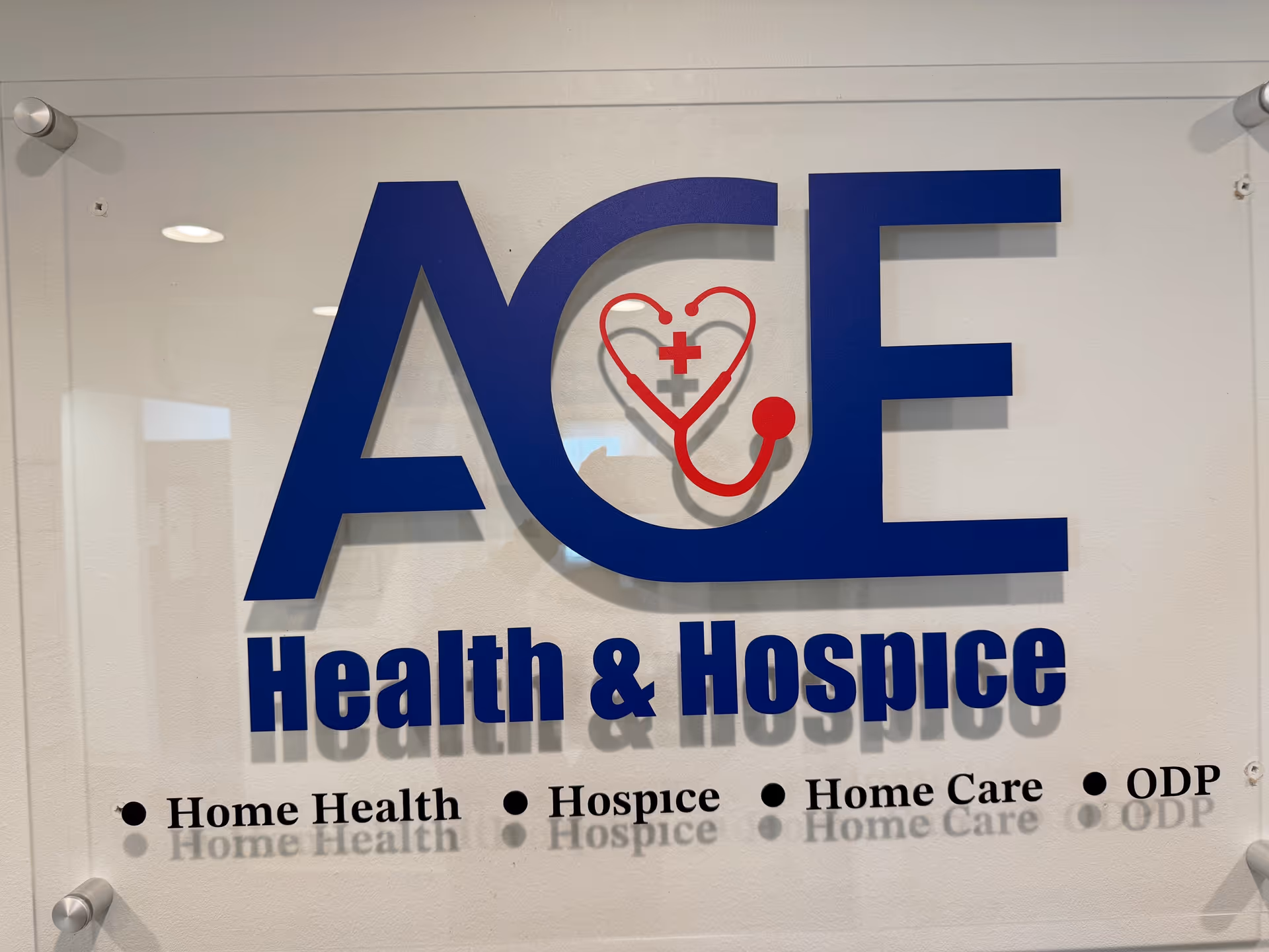 ACE Health & Hospice sign on glass wall inside facility lobby.