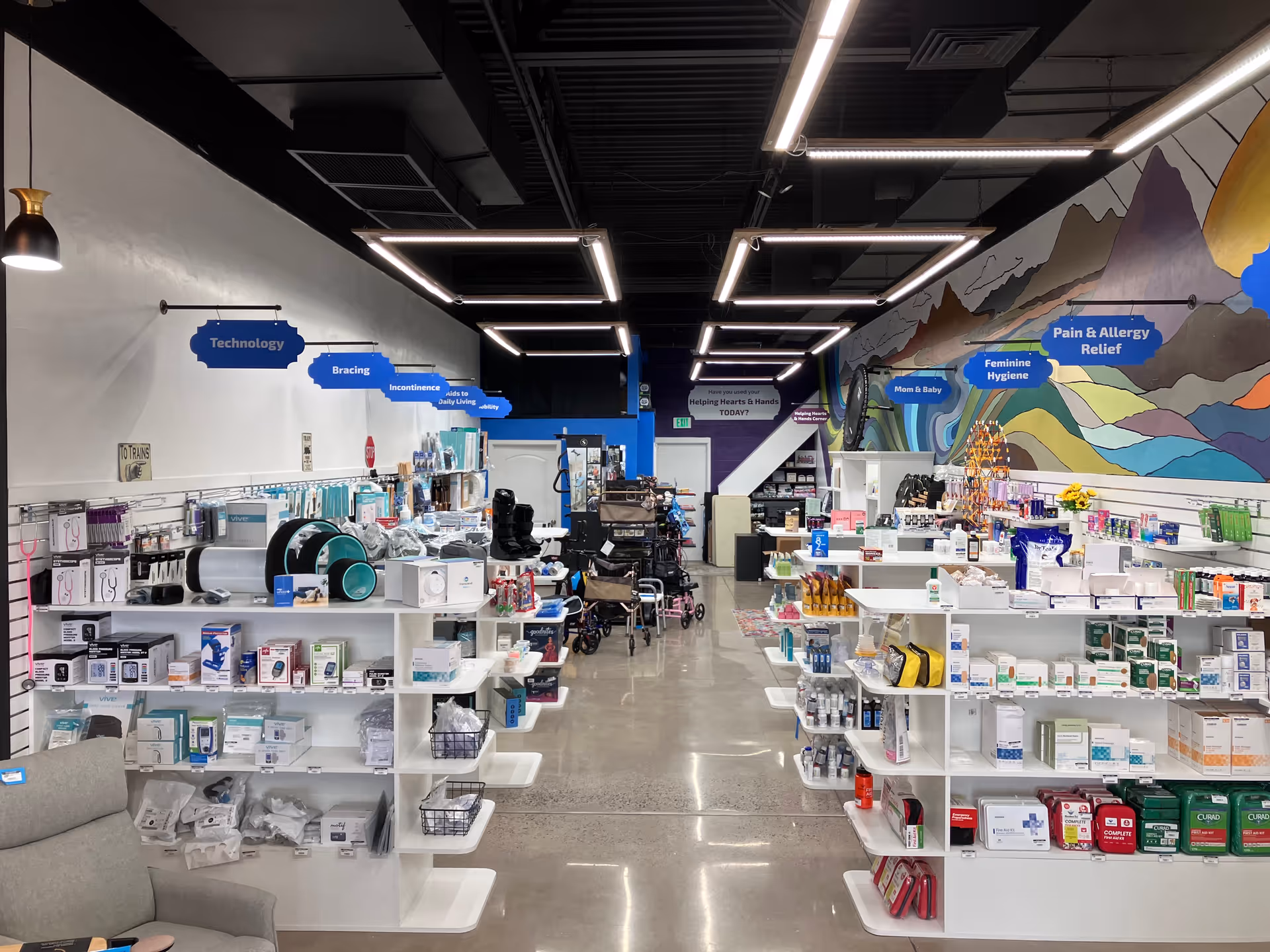 Wide aisle of a home medical supply store with shelves, products, and mural art.