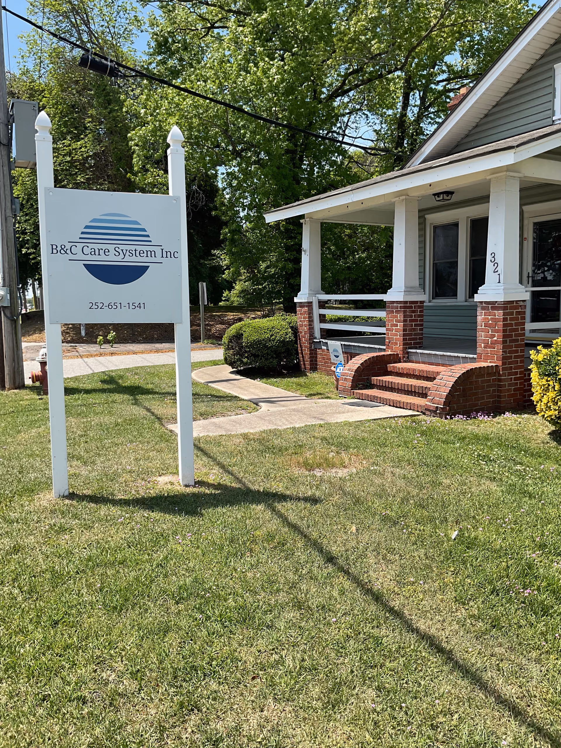 Exterior view of B&C Care System Inc building with sign and brick porch stairs.