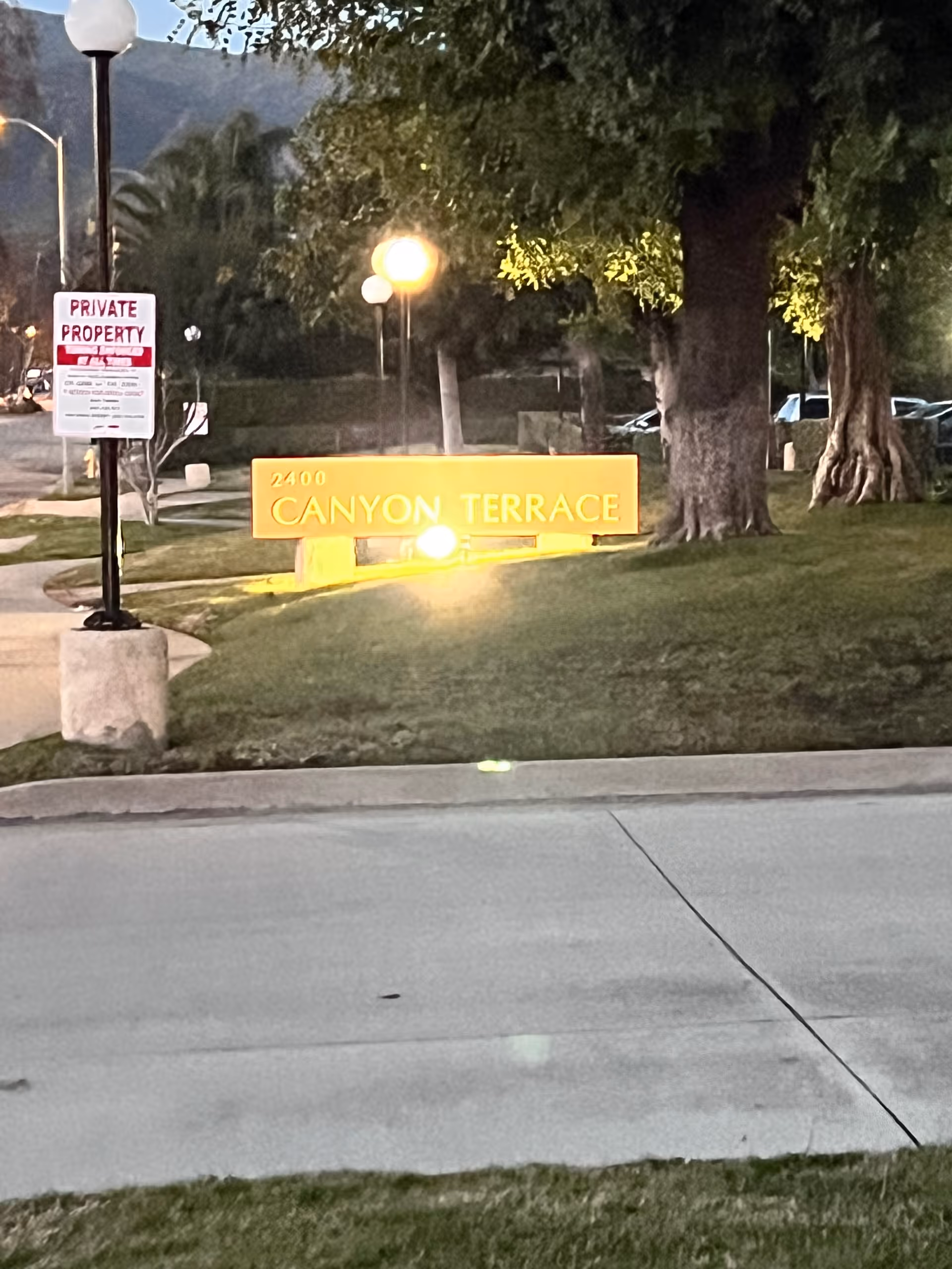 Canyon Terrace sign on a lawn with trees and a private property sign on a lamppost