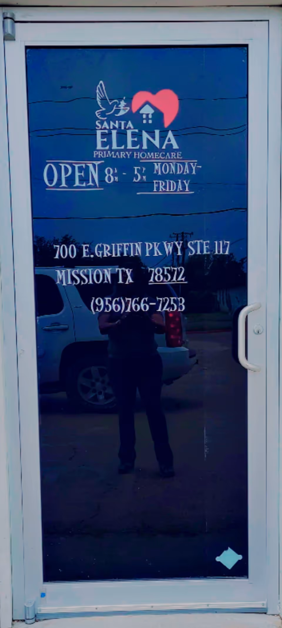 Blue glass door with Santa Elena Primary Homecare signage and contact details.