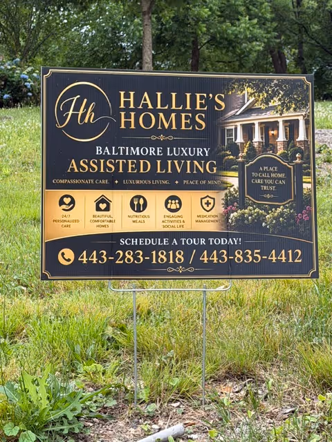 Outdoor sign for Hallie's Homes Baltimore Luxury Assisted Living on a grassy lawn.