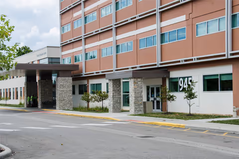 Exterior view of Physician Pavilion 945 facility with entrance, stone columns, and parking curb.