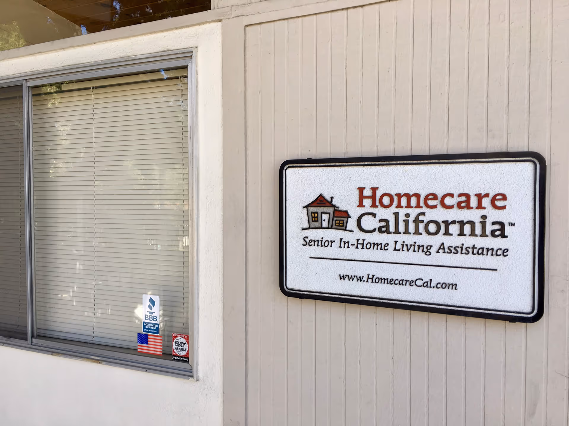 Exterior wall with a 'Homecare California' sign and window with blinds.