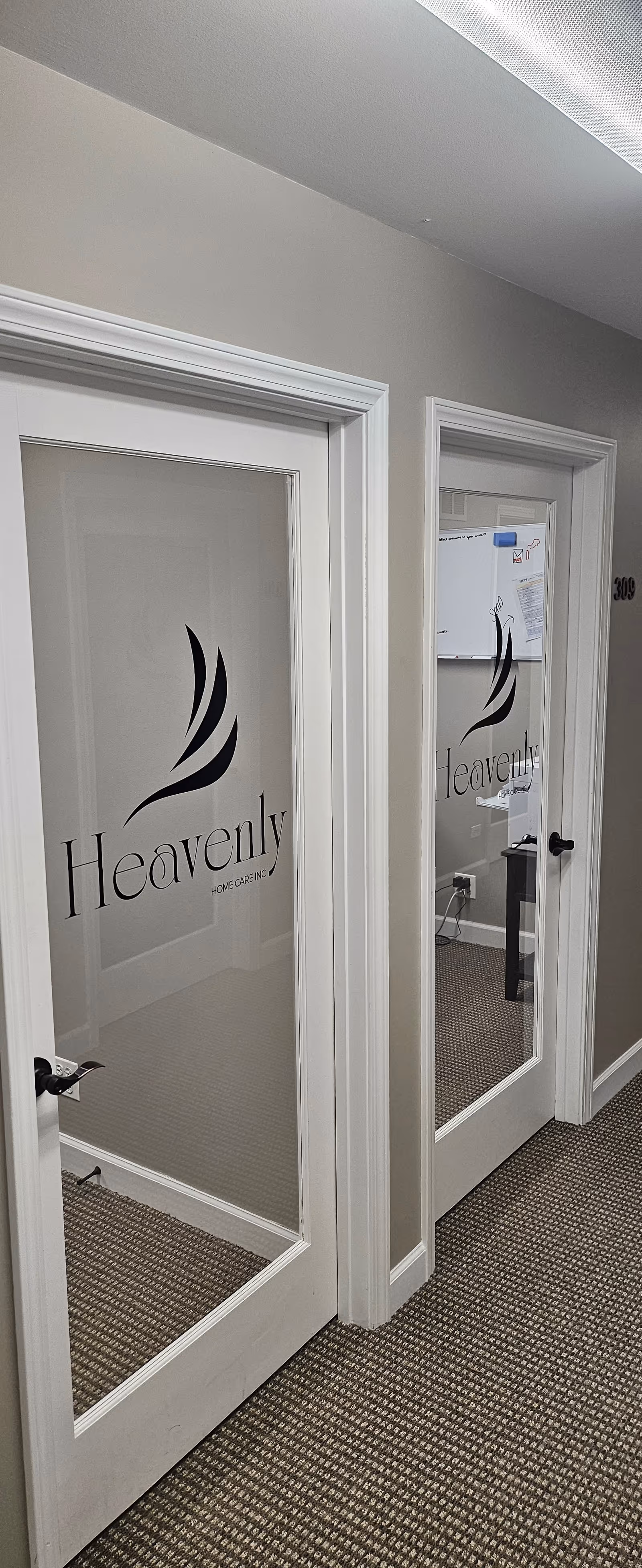 Interior hallway with frosted glass doors branded with Heavenly Home Care.