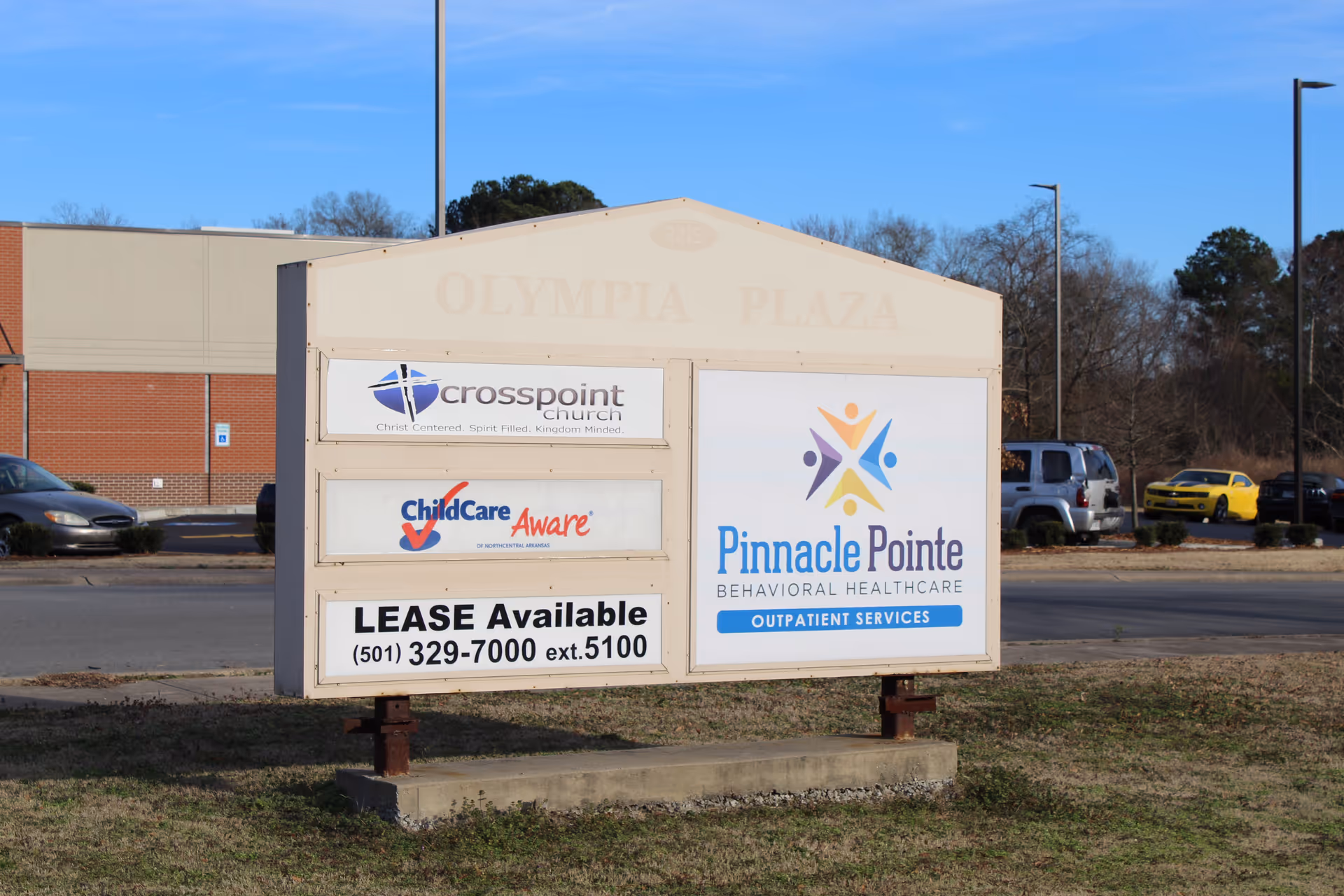 A freestanding signboard for Olympia Plaza with Pinnacle Pointe Behavioral Healthcare signage.
