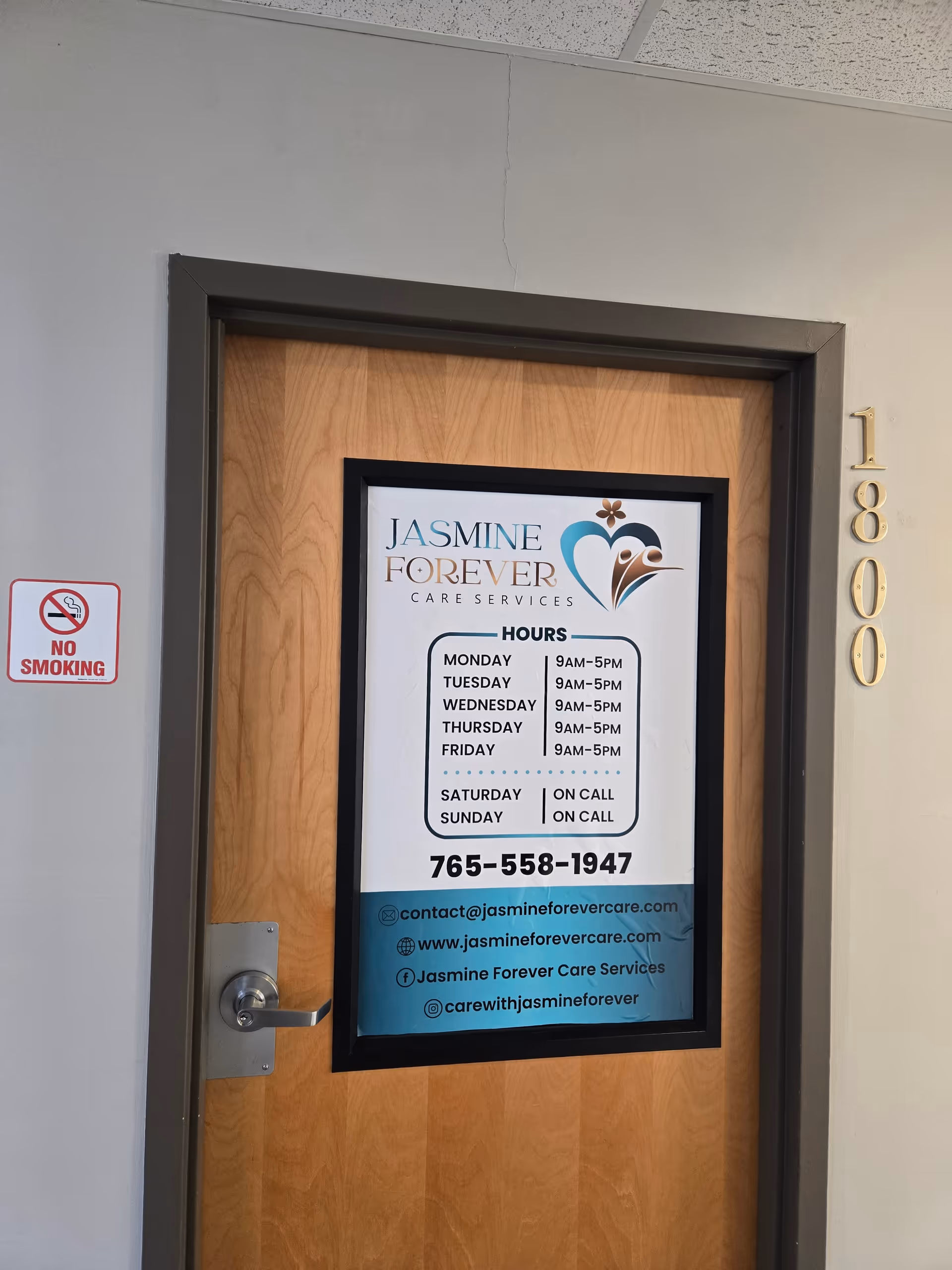 A wooden door features Jasmine Forever Care Services sign and hours in the hallway.