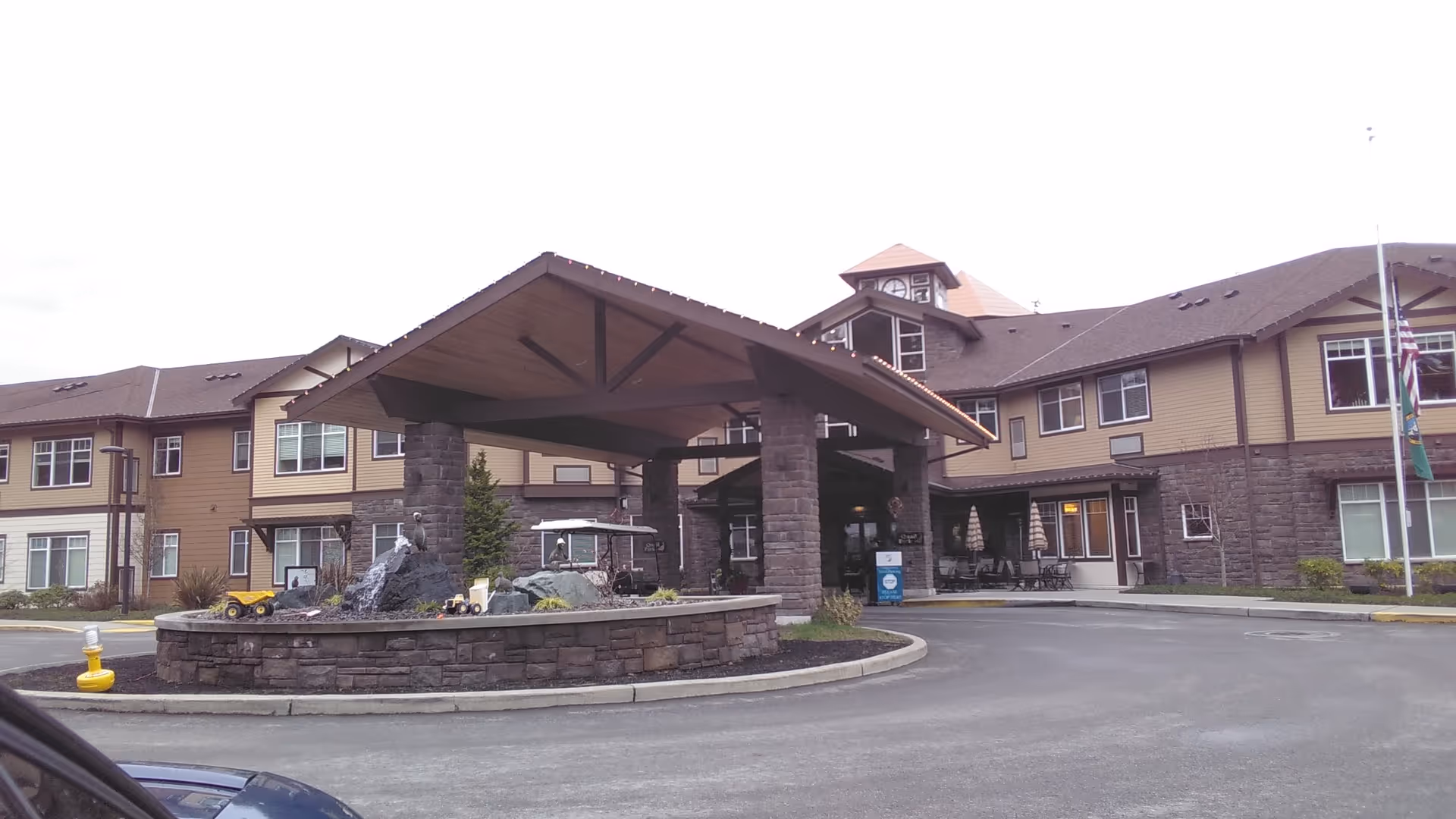 Exterior view of Quail Park of Lynnwood with a covered entrance and circular drive.