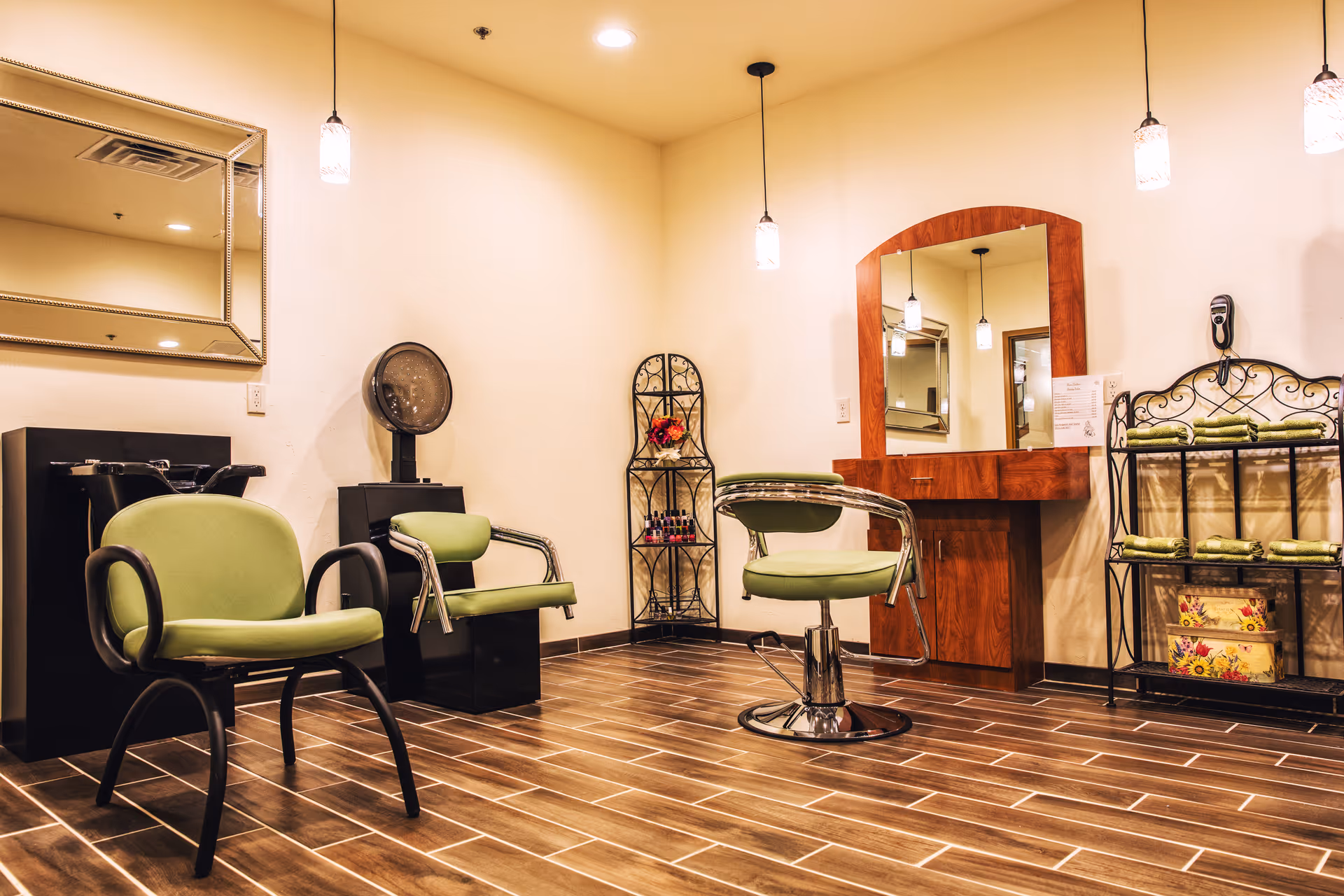A modern hair salon inside The Meadows of Fond du Lac with green chairs and mirrors.