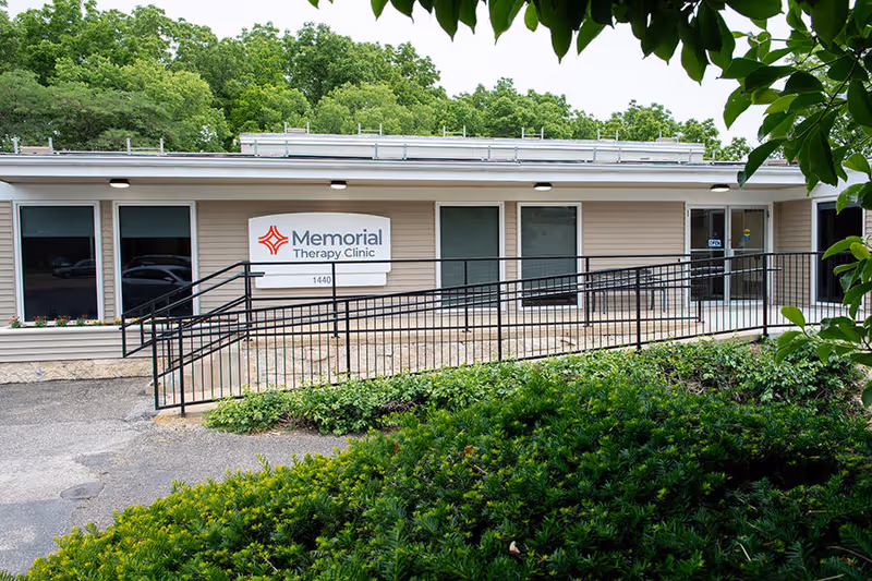 Front view of a single-story clinic with a ramp and Memorial Therapy Clinic sign.