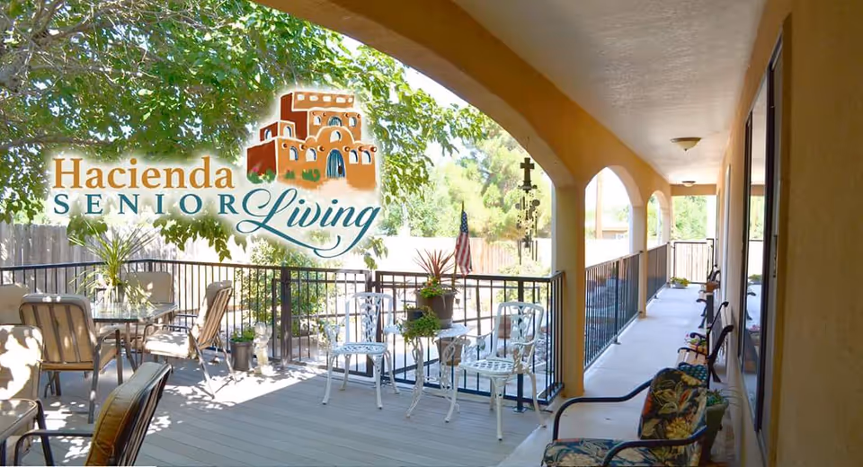 Outdoor patio deck at Hacienda Senior Living with chairs, plants, and railing.