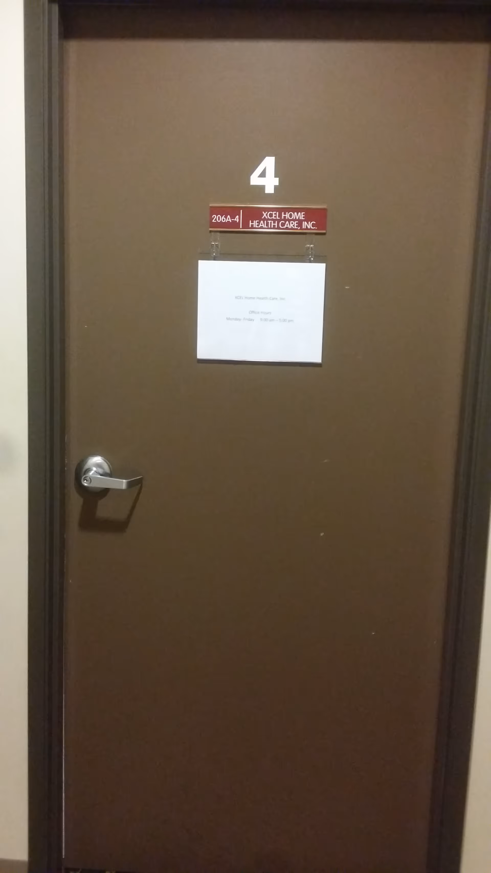 Brown interior door marked 4 with a small sign for XCEL Home Health Care, Inc.