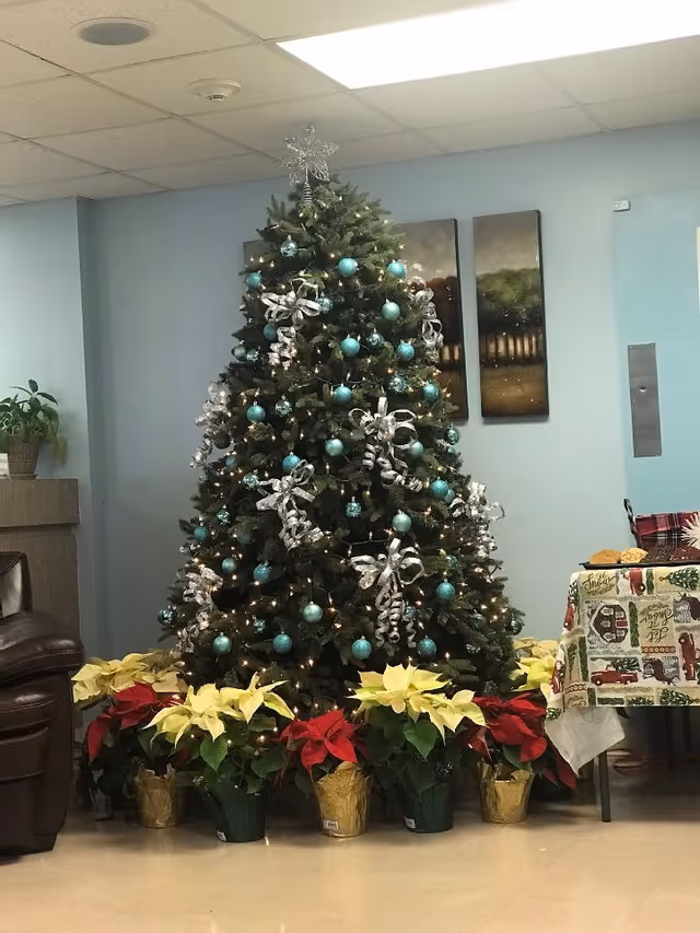 Decorated Christmas tree with turquoise ornaments and poinsettias in a facility lobby
