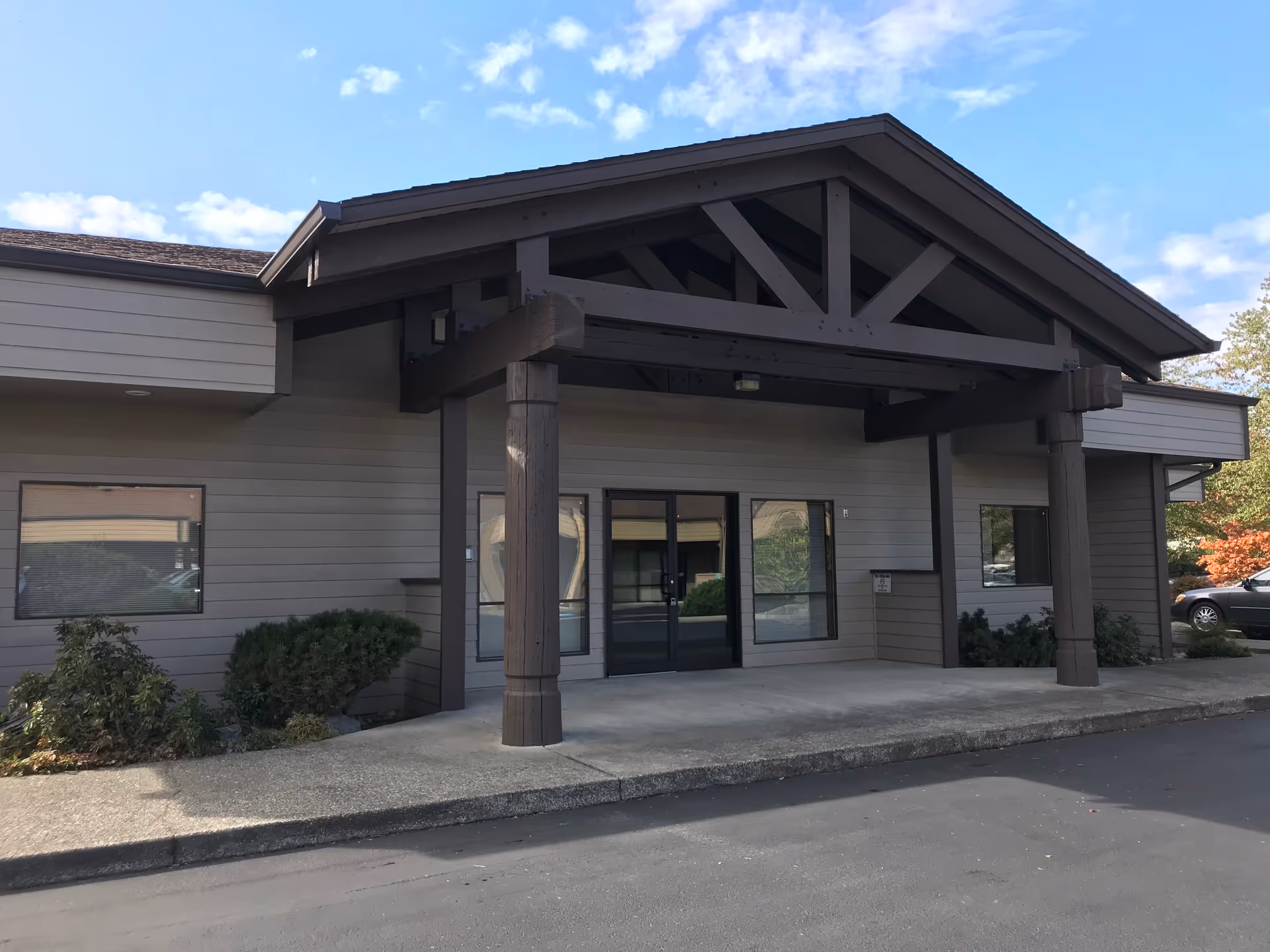 Front entrance of a modern senior care facility with a covered porte-cochère.