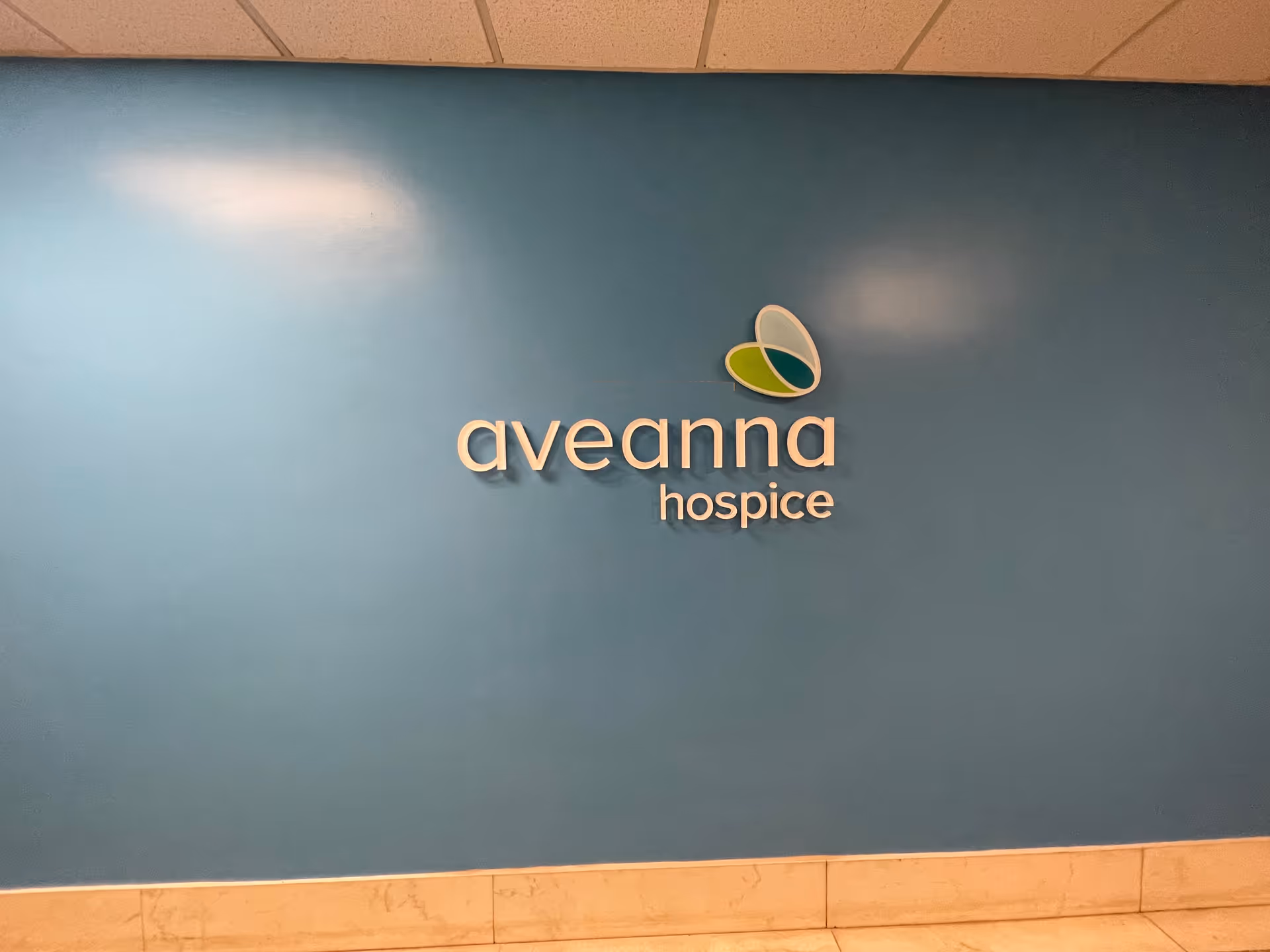 Blue interior wall featuring Aveanna Hospice logo and sign.