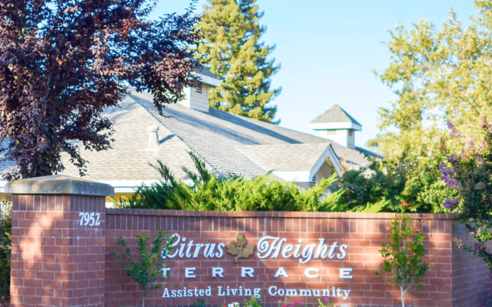 Brick entrance sign reads Citrus Heights Terrace Assisted Living Community, with trees and building behind.