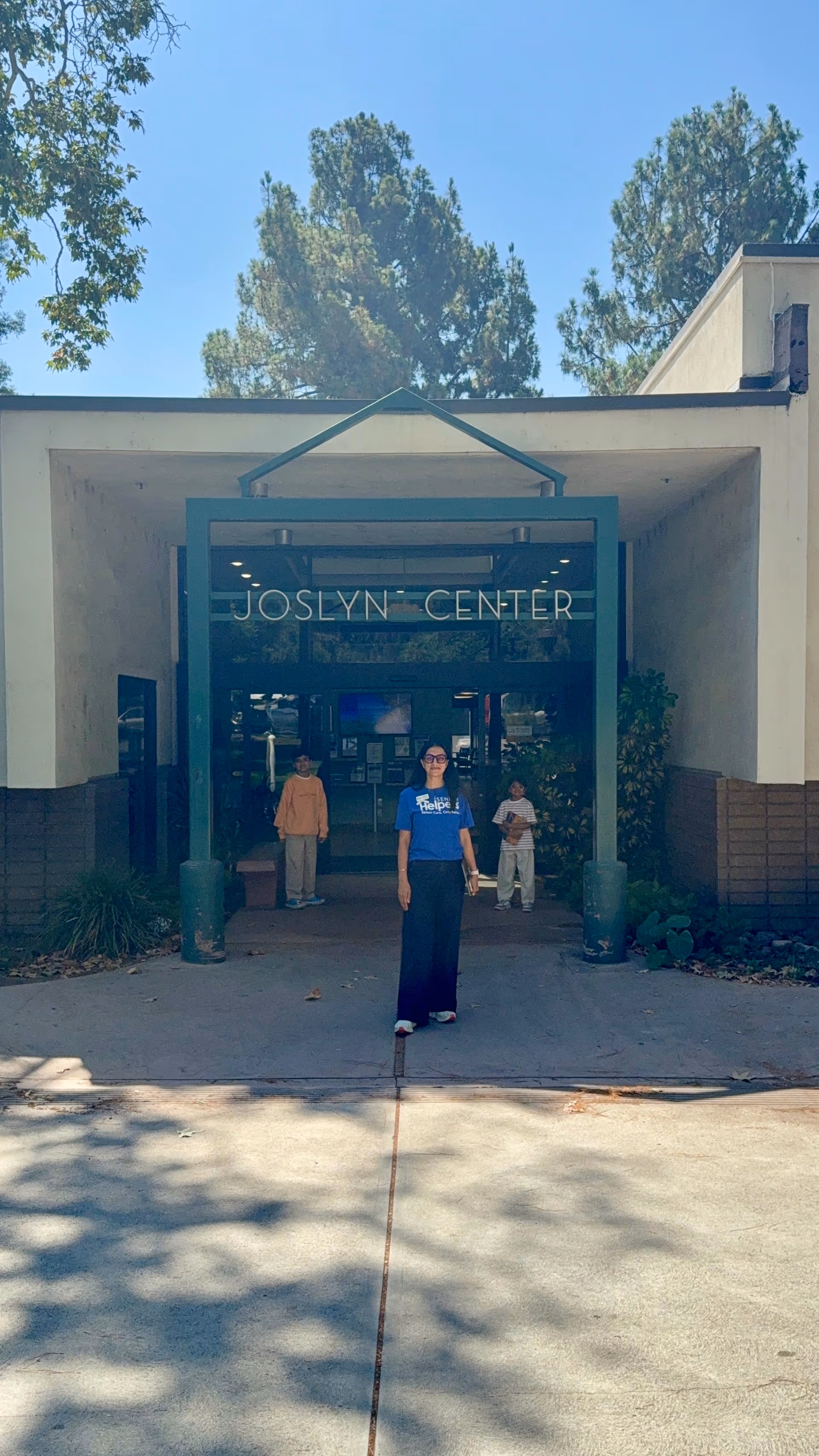 Front entrance of Joslyn Center with three people standing outside on a sunny day.