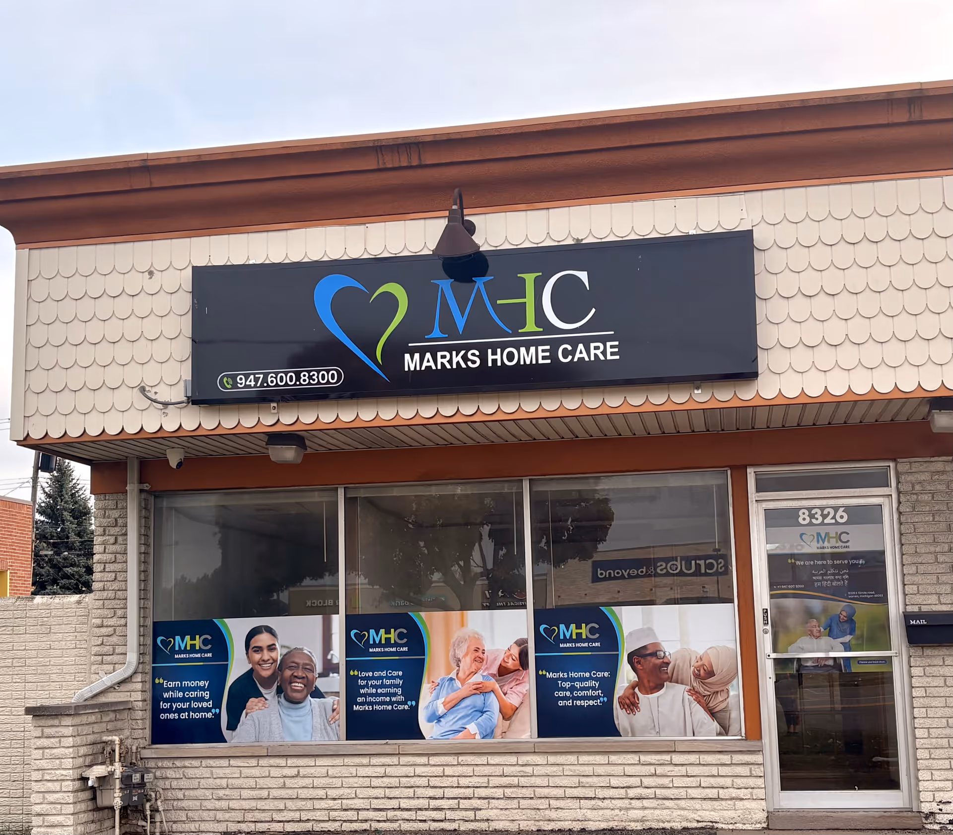 Exterior view of Marks Home Care building with sign and promotional window posters.