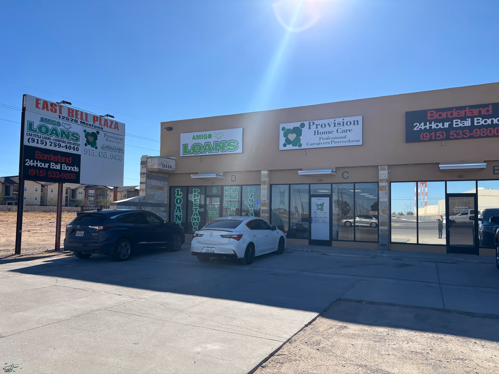 Exterior of a retail strip mall featuring Provision Home Care sign and parked cars.