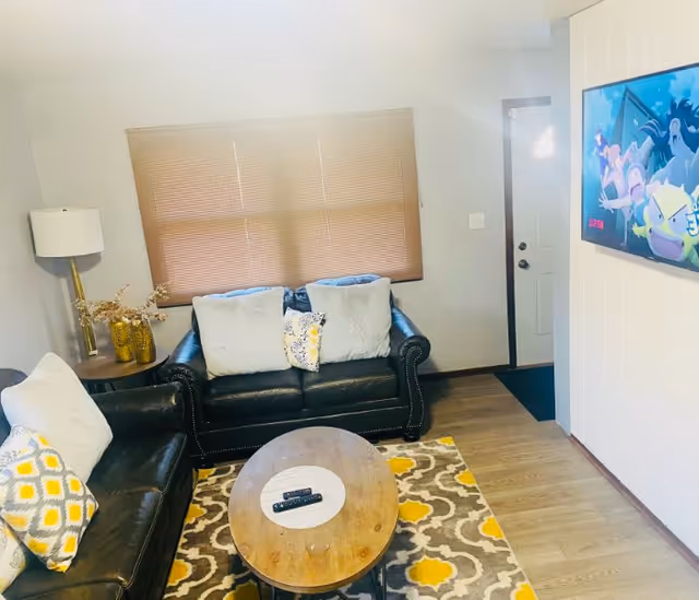 Cozy living room in a senior living facility with leather sofas and TV.