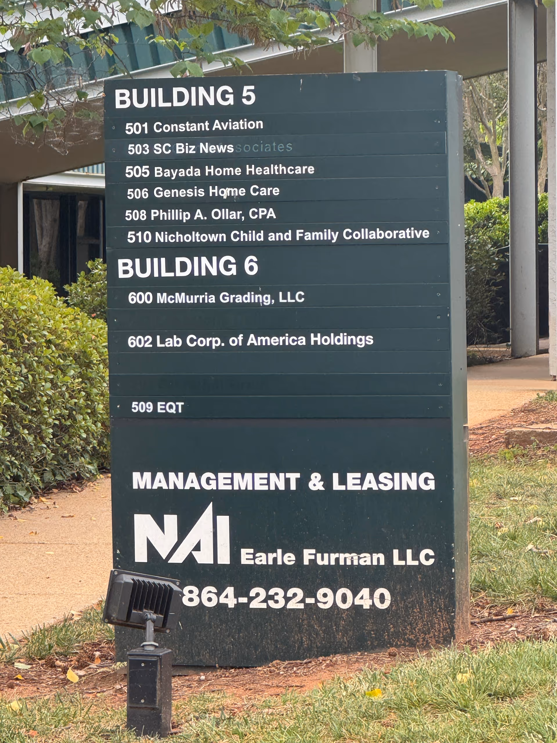Outdoor signboard listing buildings and Genesis Home Care branding.