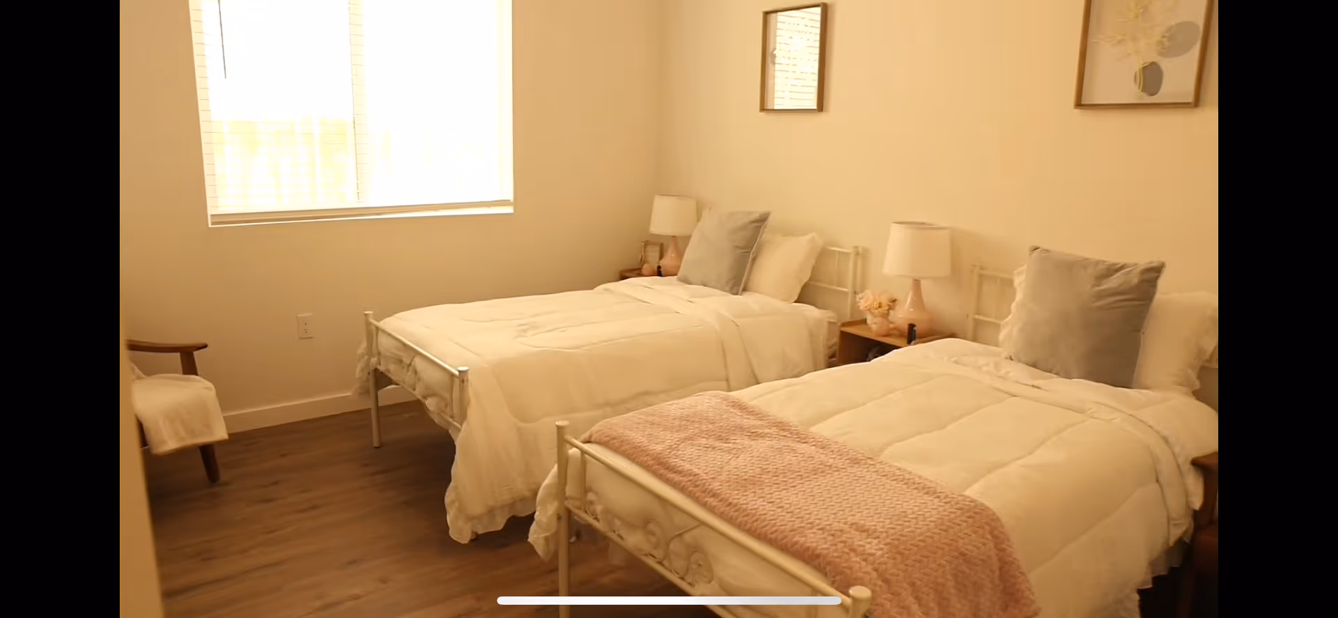 Two matching beds with white bedding and nightstands in a bright, tidy bedroom.